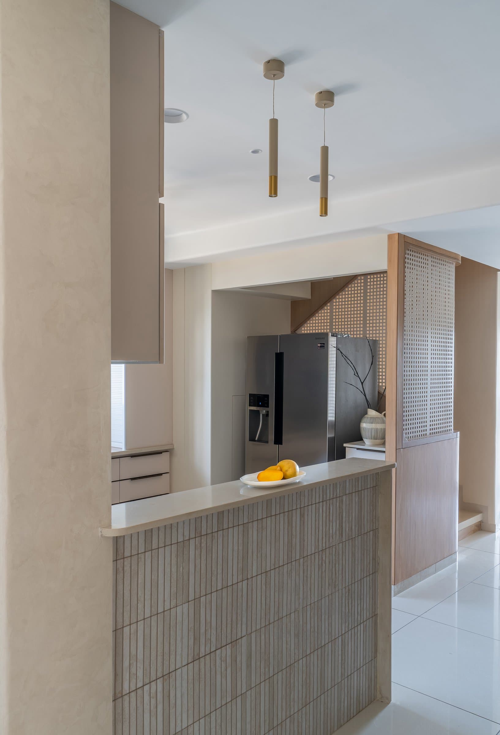 The kitchen, partially screened by a tile-clad half-height counter and a cane-panelled sliding partition