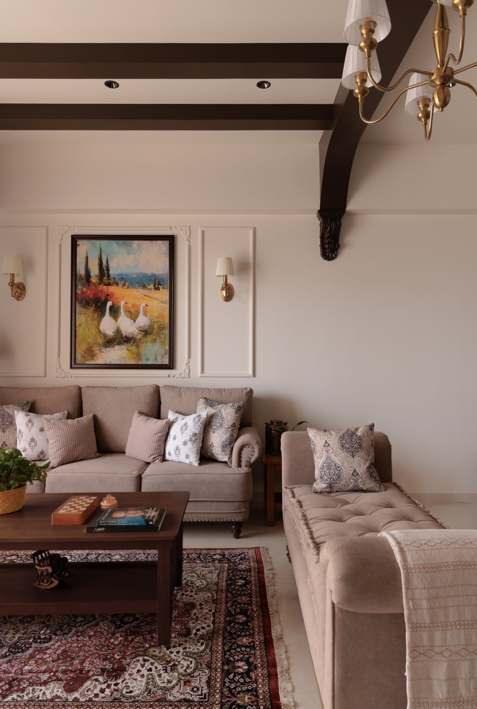 A closer view of the panelled wall and corbel detail, where a landscape painting is framed between brass sconces