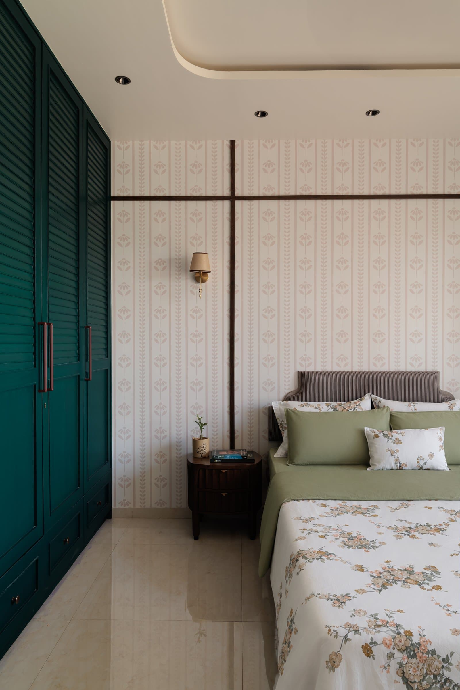 The daughter's bedroom, where deep green louvred wardrobes meet a botanical wallpaper framed by a slender wooden grid