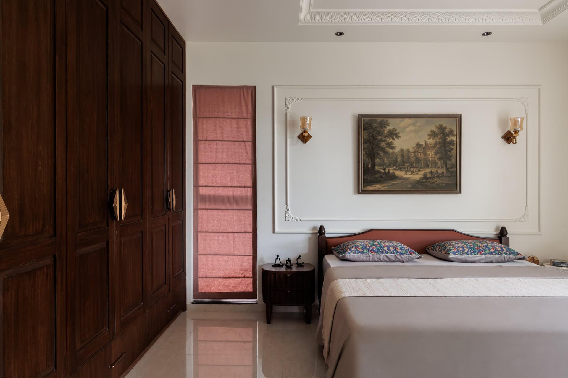 In the parents' bedroom, dark panelled wardrobes face a plaster-moulded wall holding a vintage-style landscape