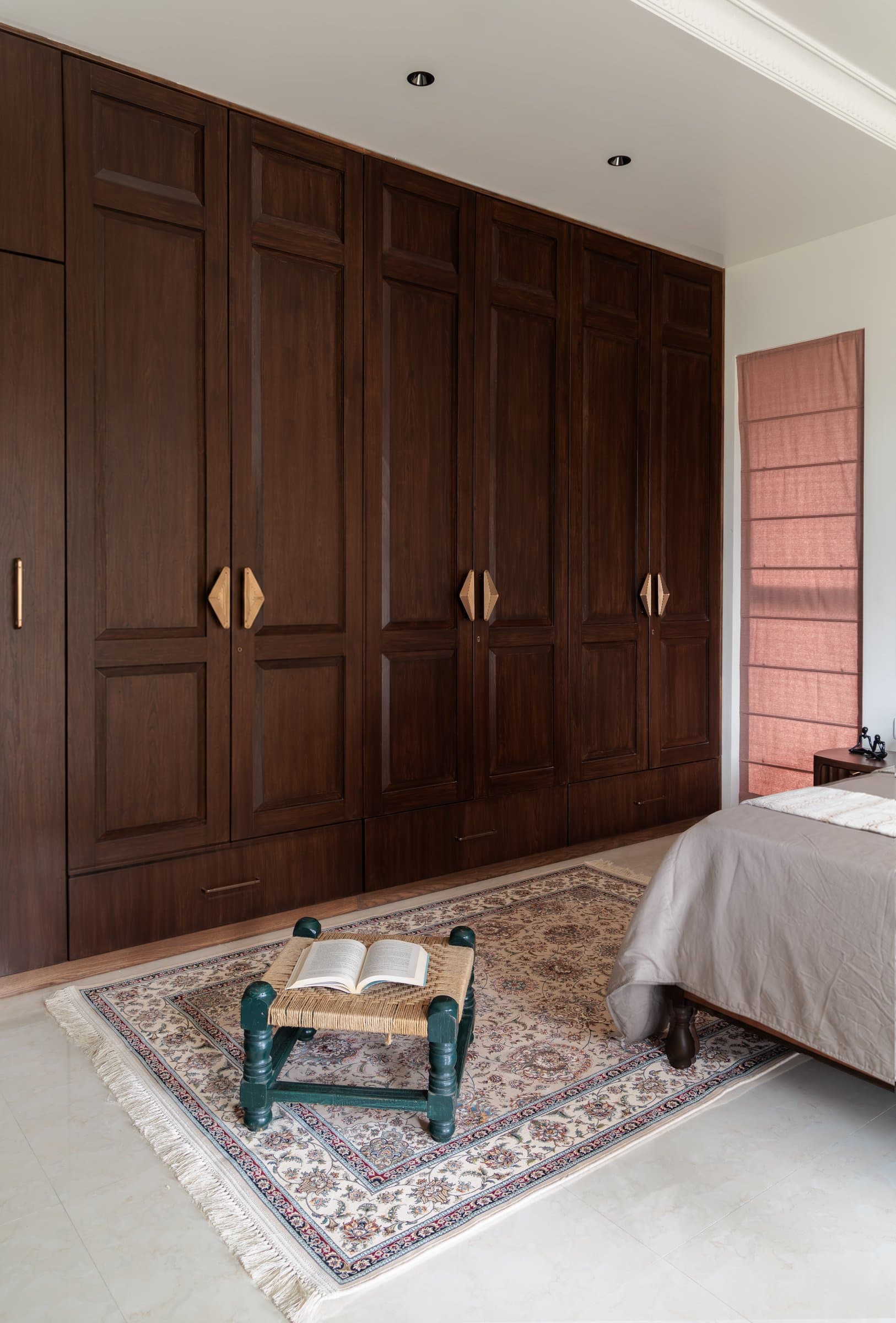 The wardrobe wall in full, its sculptural handles pairing at the centre of each unit