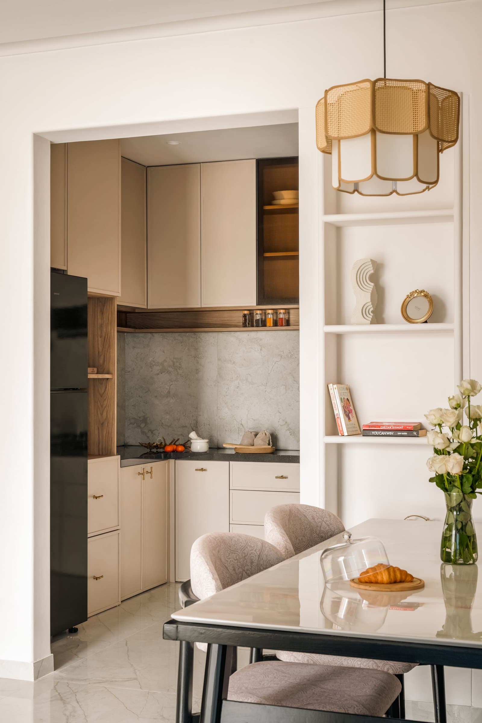 Viewed from the dining area, the kitchen reads as a framed vignette within the shared material palette