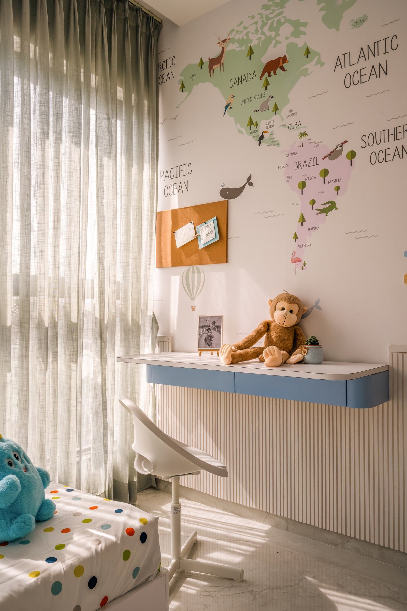 The children's bedroom, where a world-map wallpaper meets a wall-hung writing desk with a soft blue accent