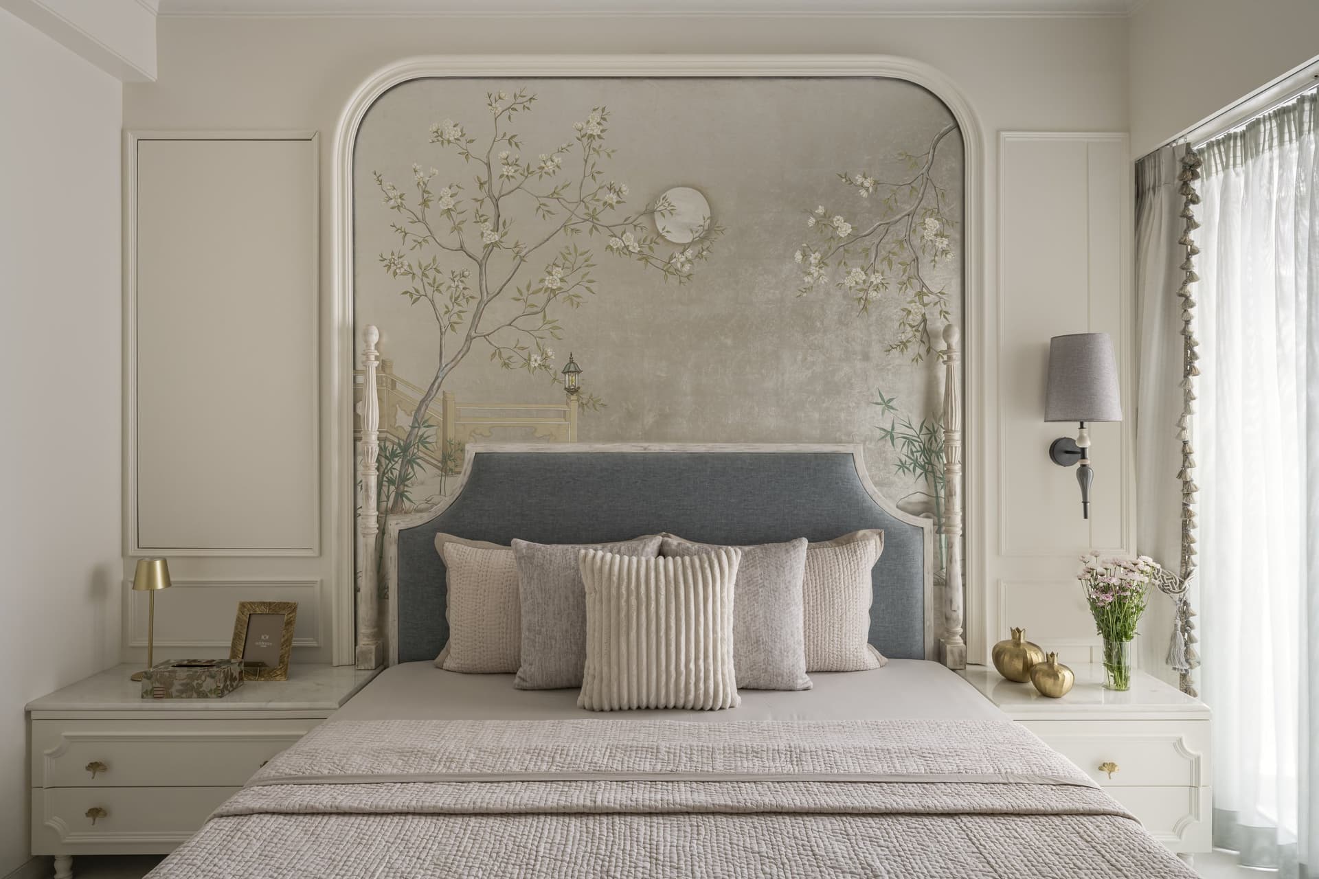 The master bedroom, where a hand-painted Chinoiserie mural by the studio is framed within an arched moulded surround behind the bed