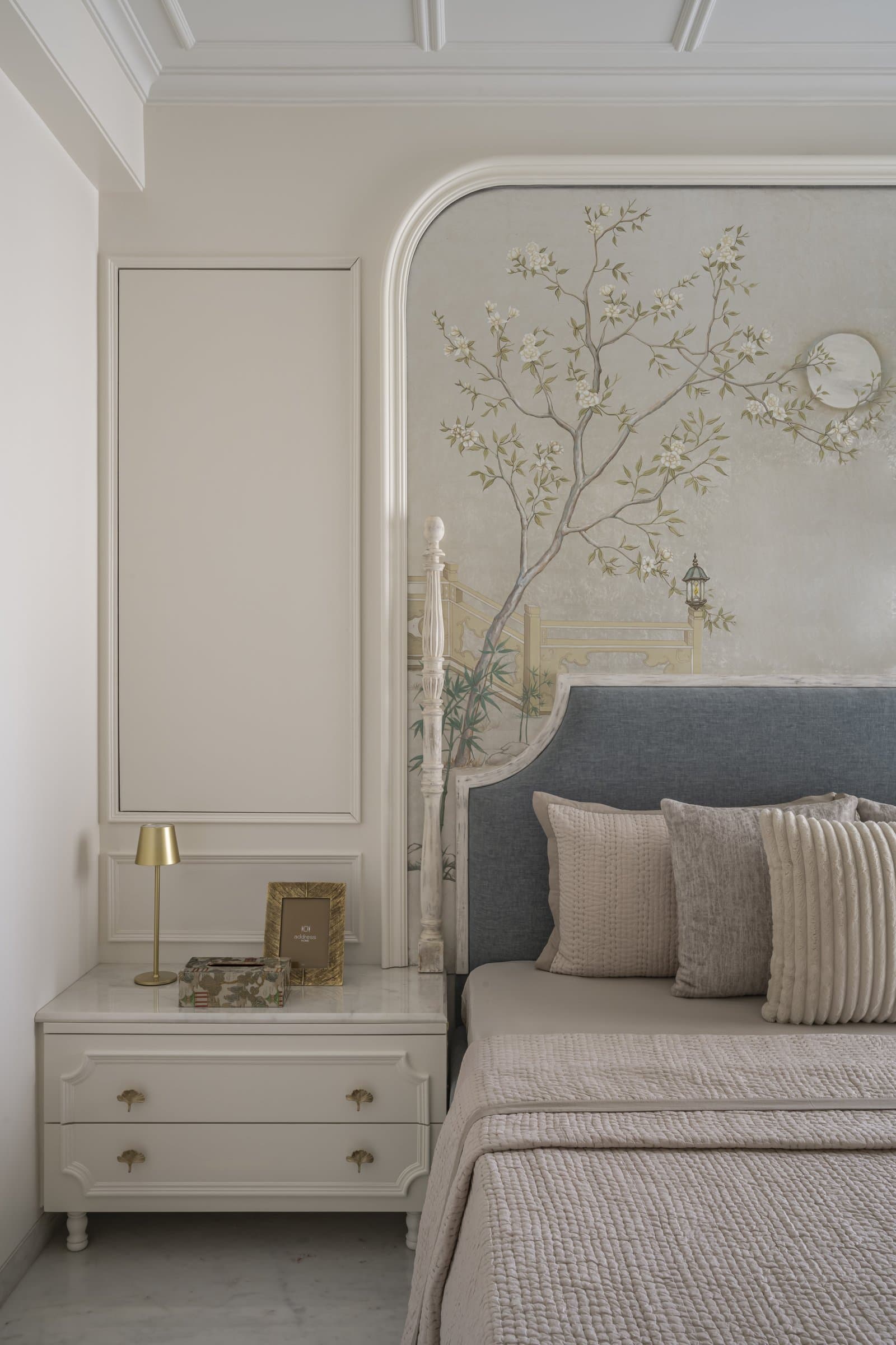 The side composition of the master bedroom, with its moulded panelling and ginkgo-leaf brass pulls on the bedside console