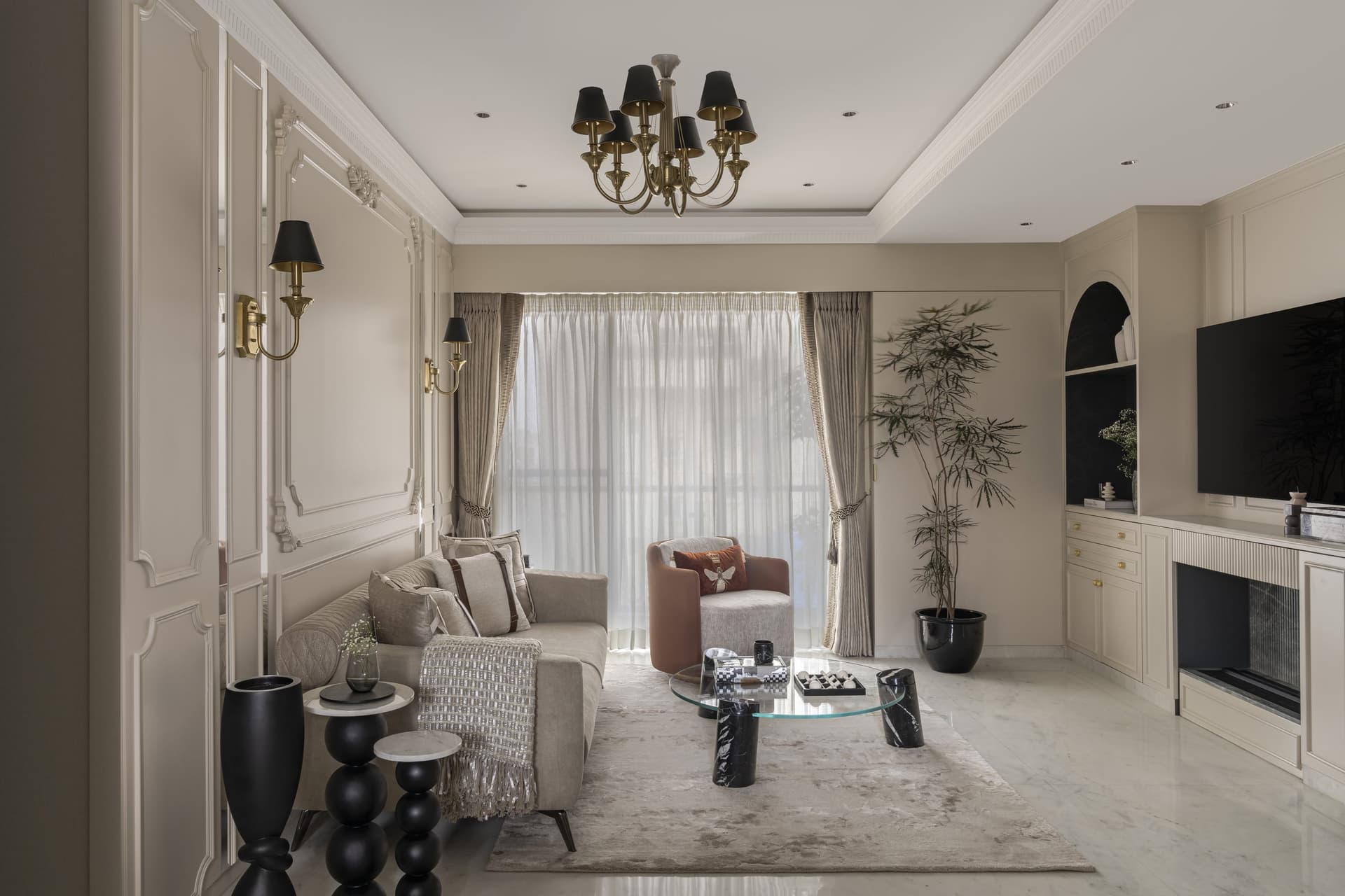 The living room, where moulded wall panelling and a brass chandelier with black shades establish the English note