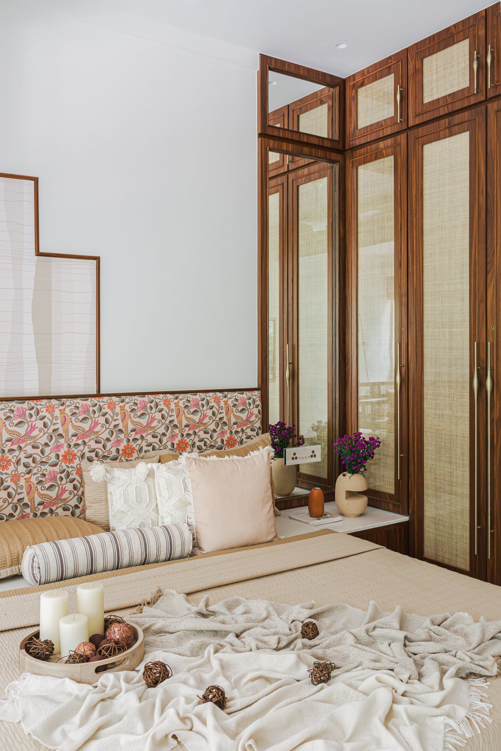 Seen from the bed, the cane-fronted wardrobe wall reads as a composed wooden facade more than storage