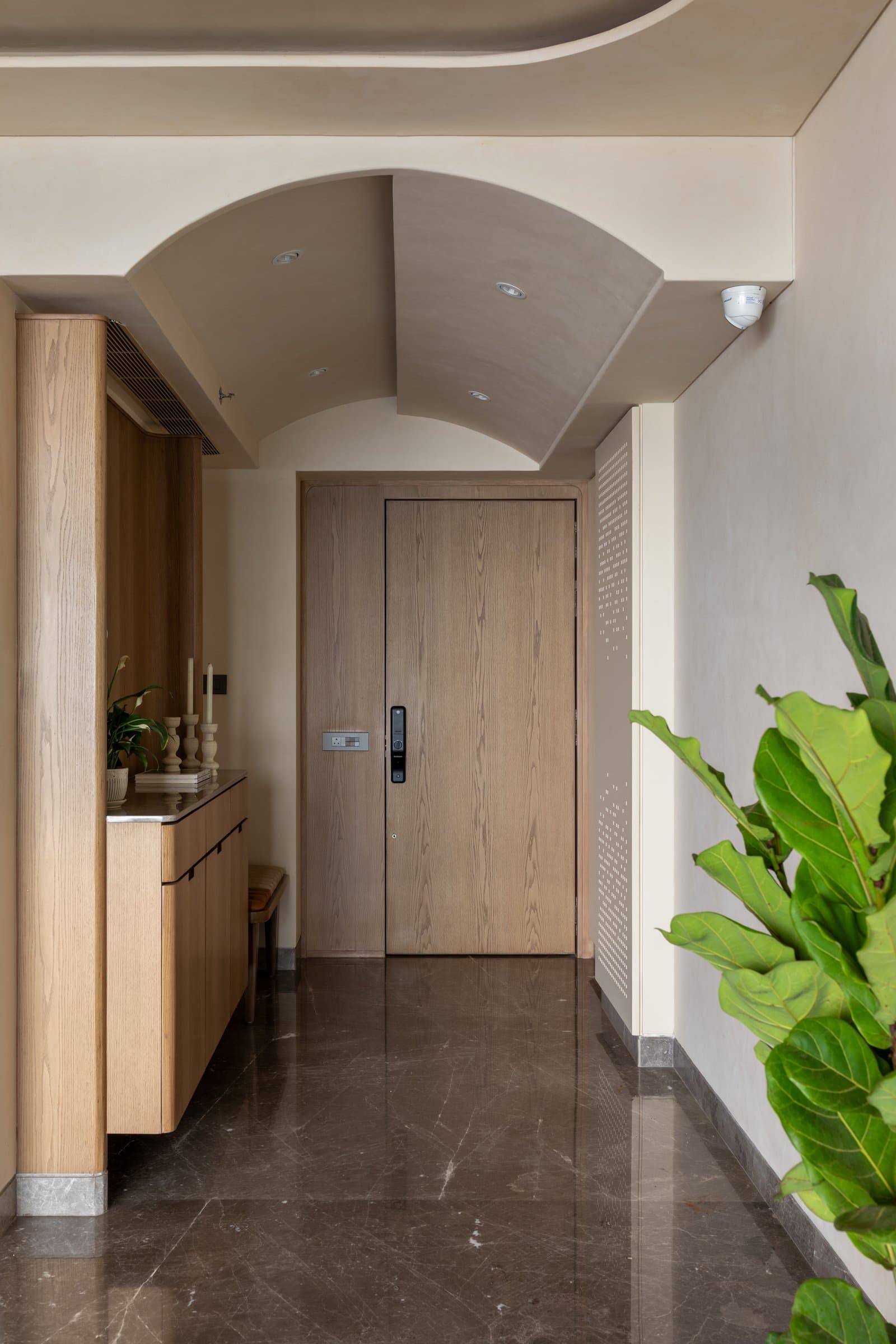 The entry foyer, where a microcement barrel-vault ceiling and a veneered oak console set the home's quiet material language