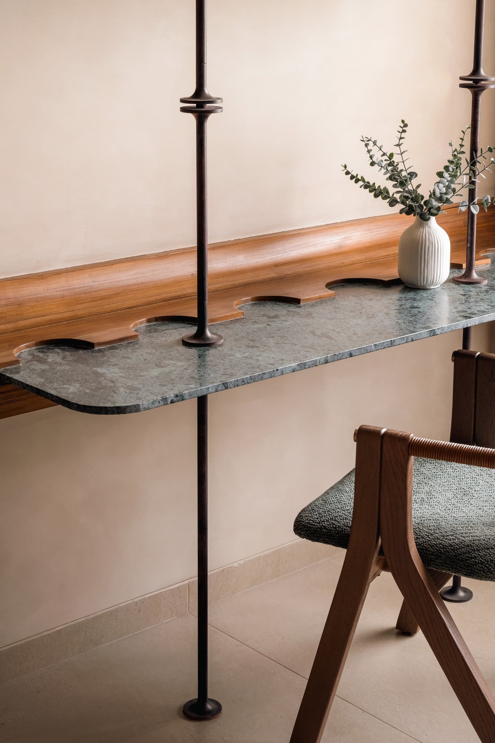 A closer view of the study desk, its scalloped marble edge echoing the home's organic language
