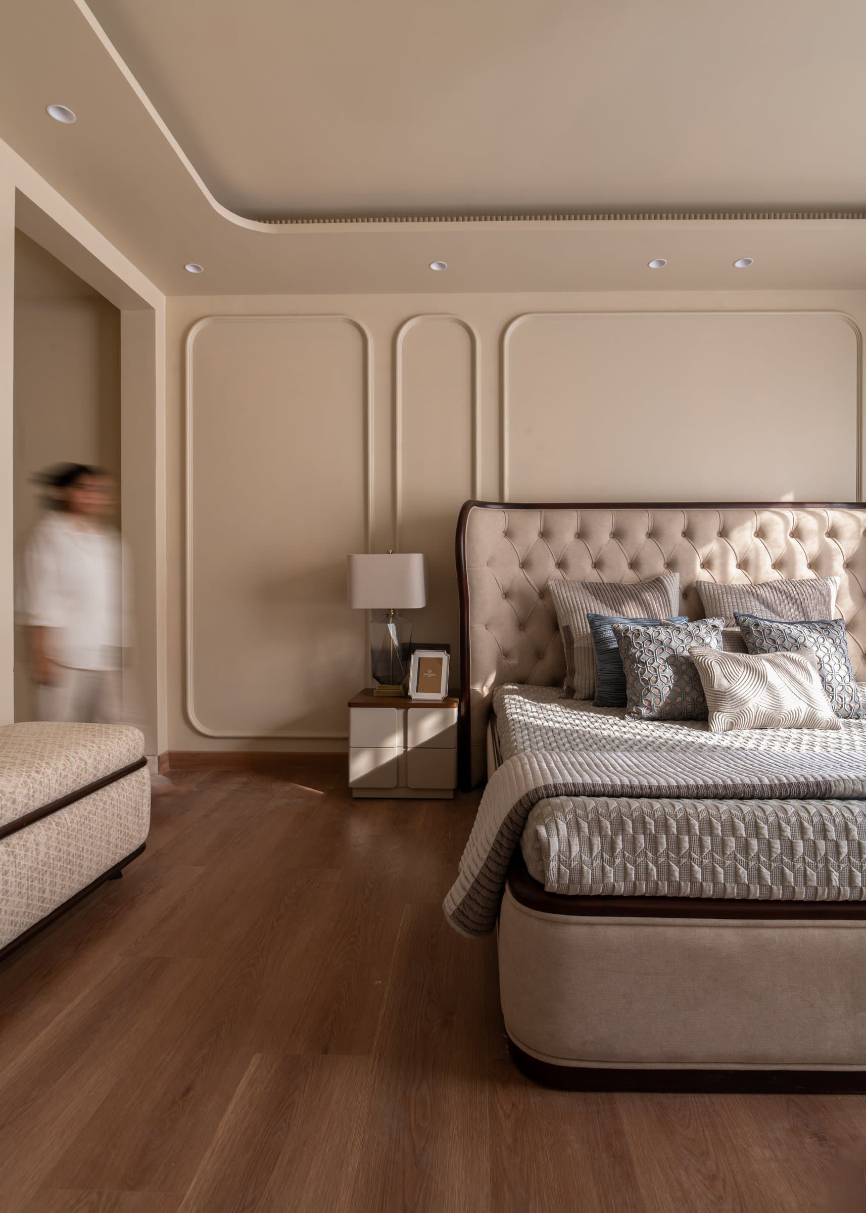 A wider view of the master, where the arched panelling frames the bed as though it were a monument within the architecture