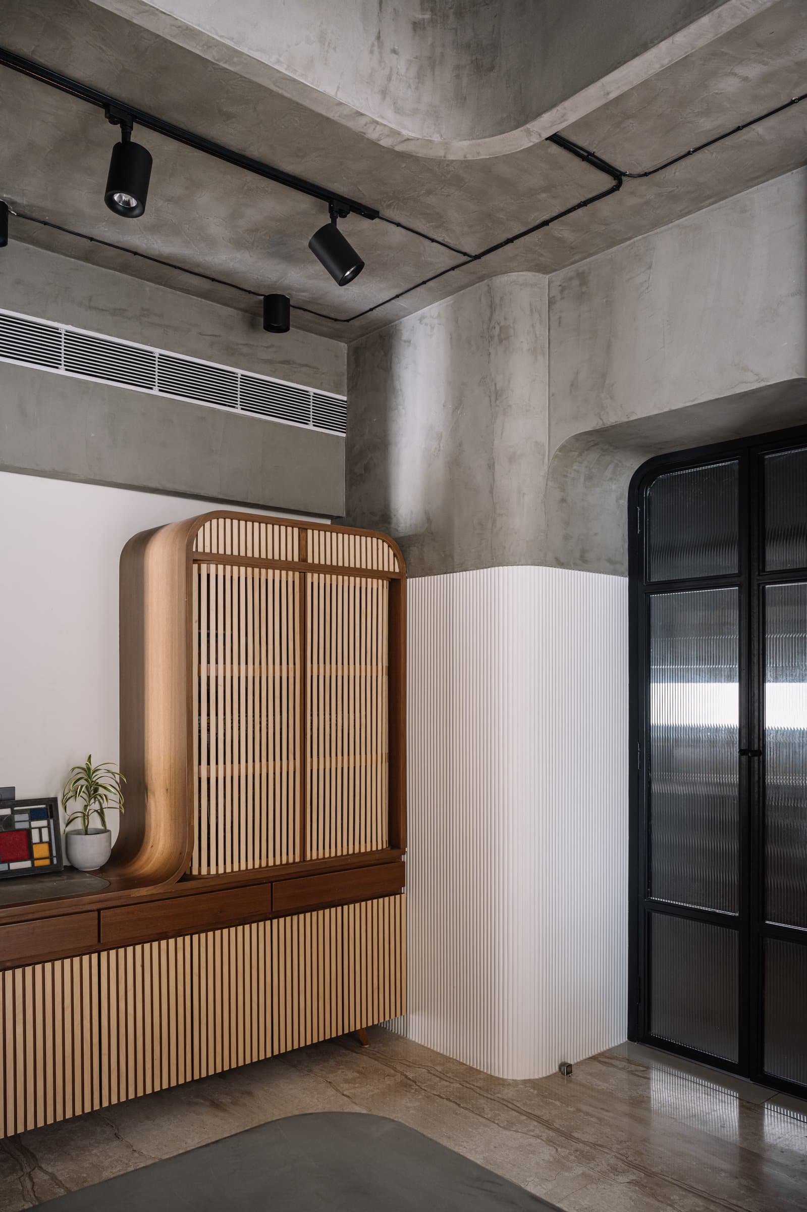 The mandir unit and kitchen corner, where the concrete ceiling sweeps in continuous undulation between zones