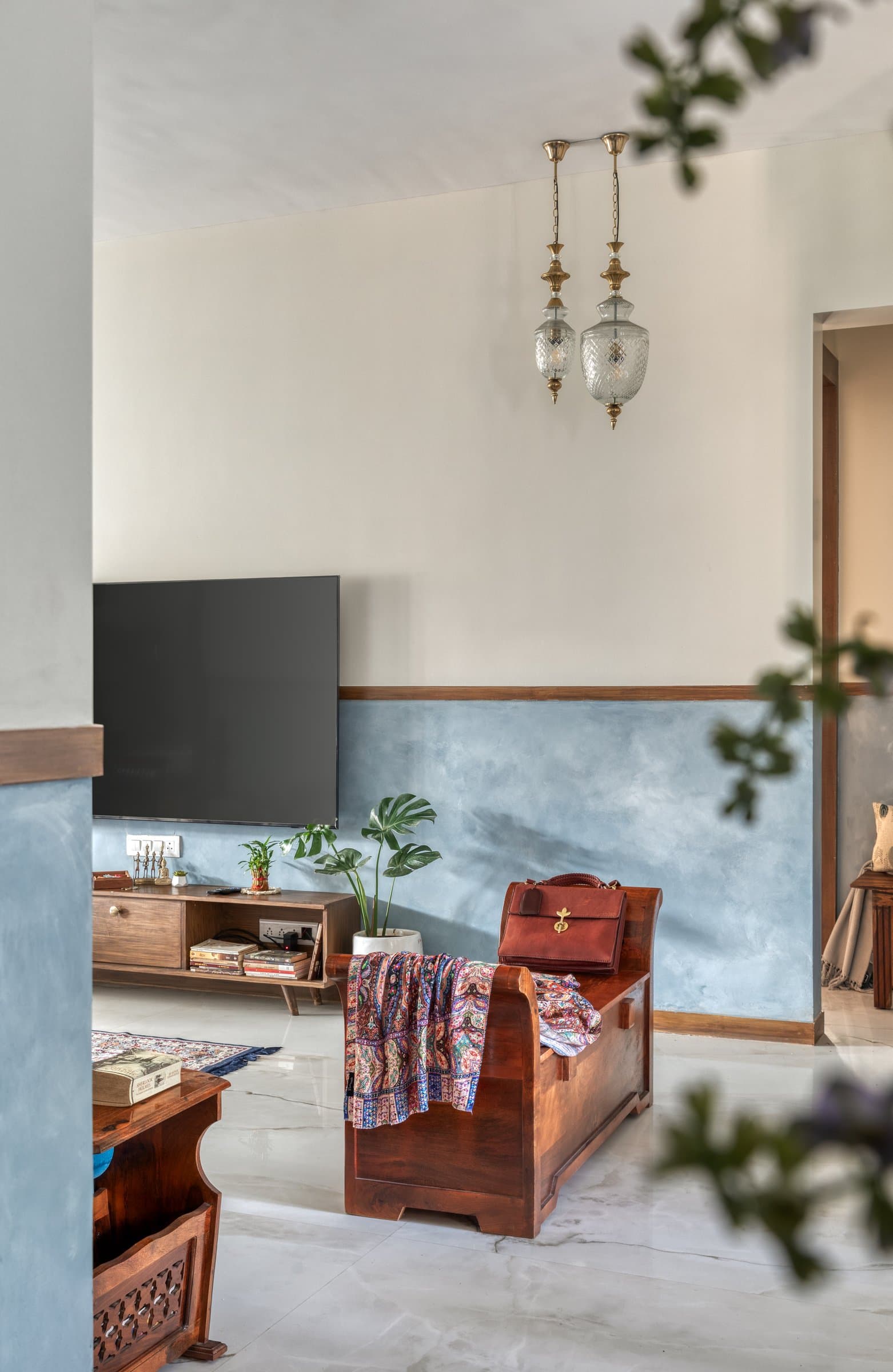 The media wall and storage bench, where cut-glass lanterns create a gentle echo of the foyer beyond