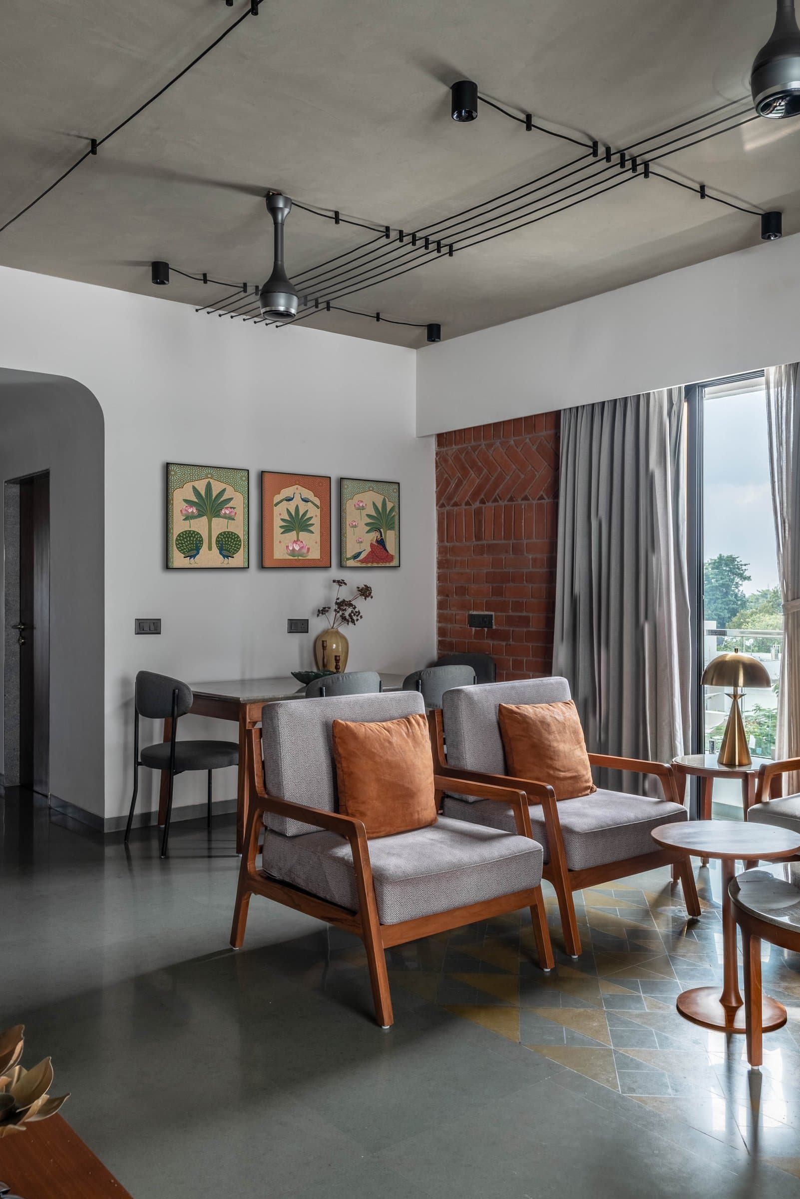 A wider view connecting living and dining zones, with botanical prints bridging the two