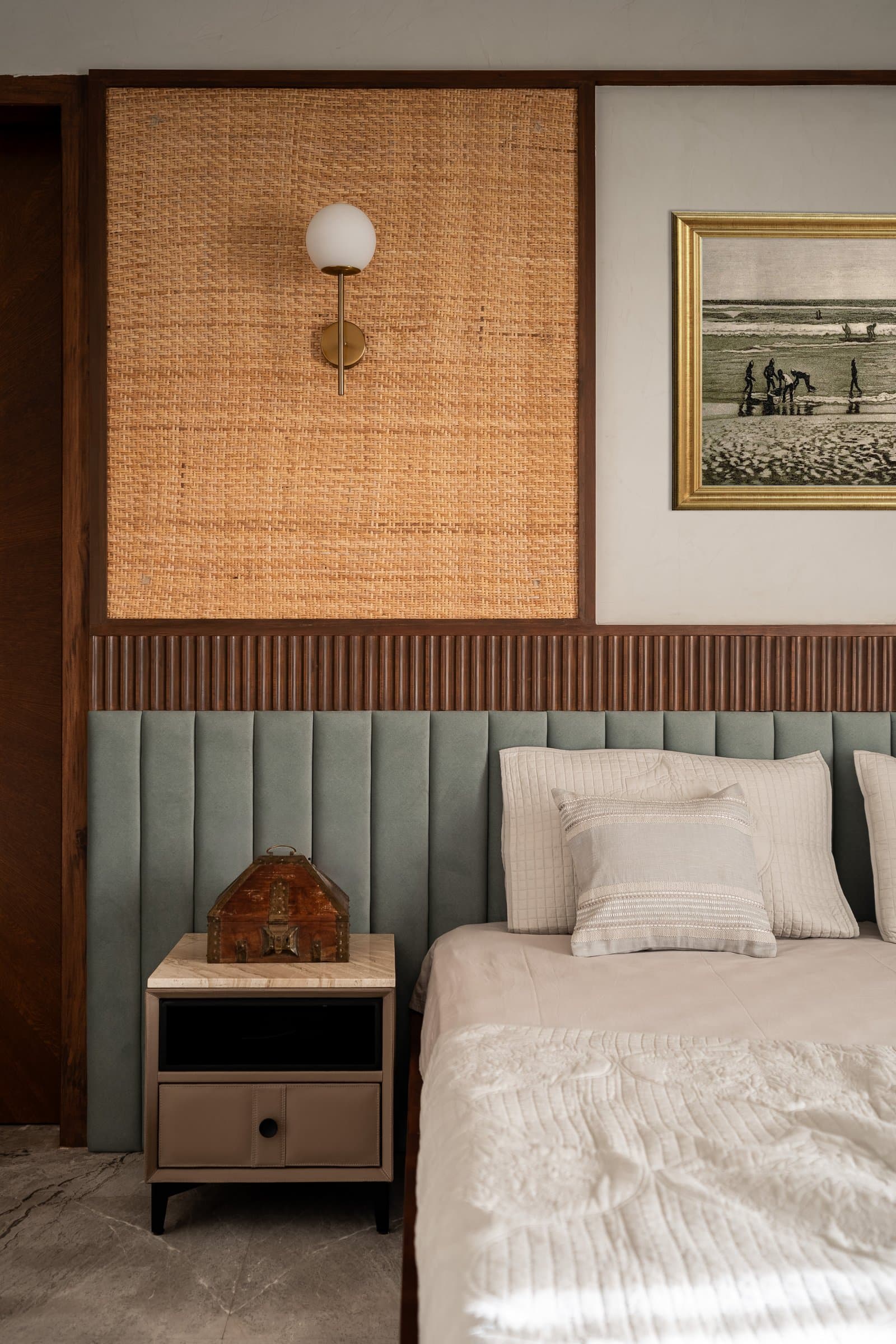 The detail: cane, fluted wood, channel-tufted upholstery, and a small antique trinket box that earns its place by looking its age