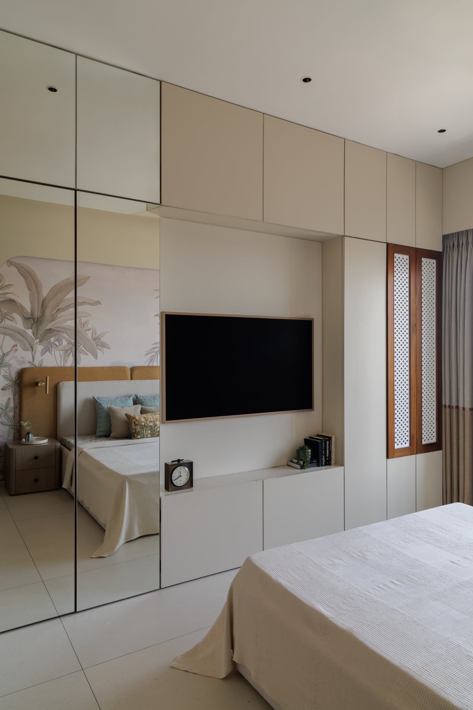 The television wall, where fretwork shutters acknowledge older Indian carpentry within an otherwise contemporary composition