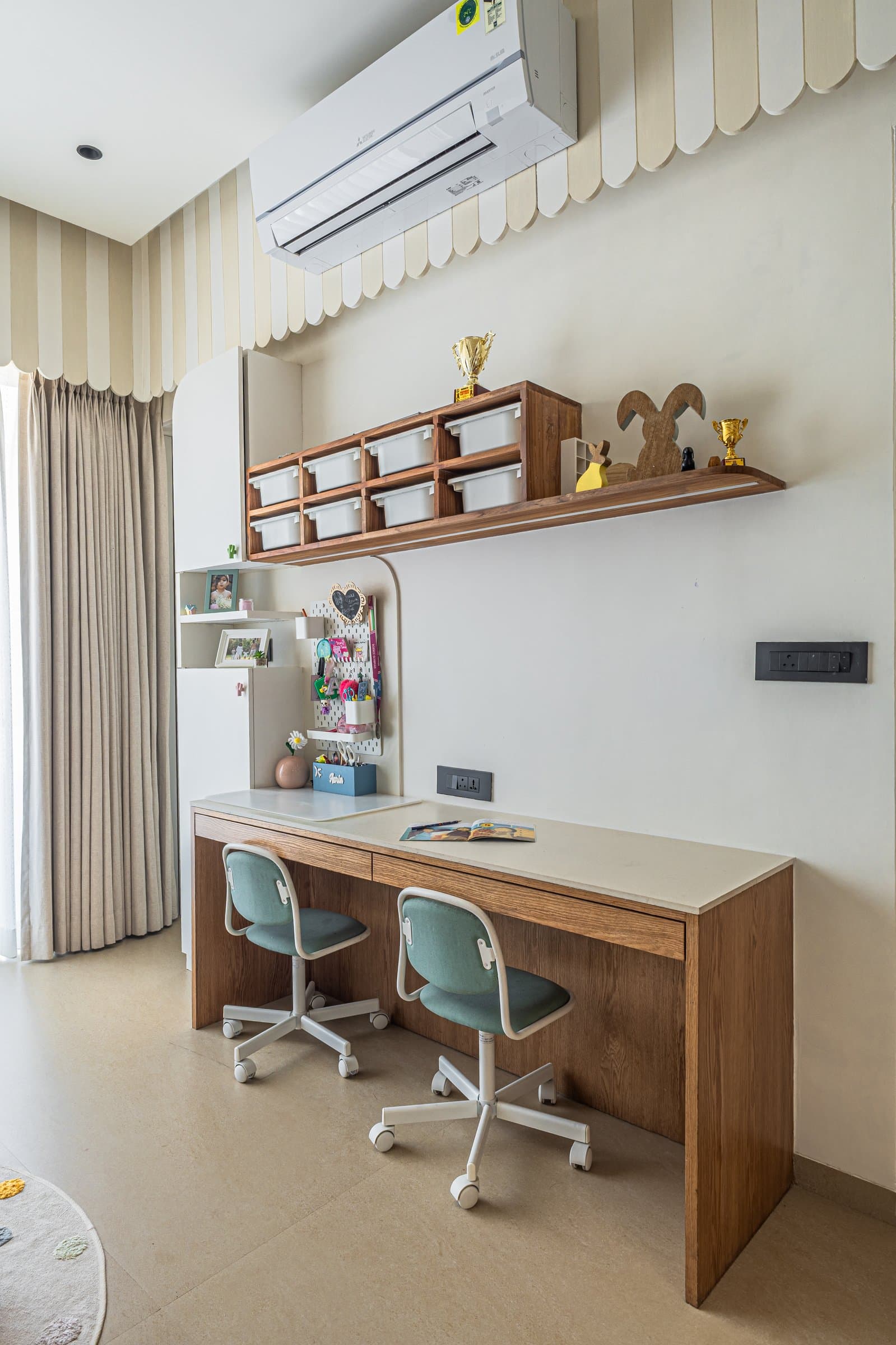A study counter in warm wood with swivel chairs and labelled bins, designed for how the children will grow into the room