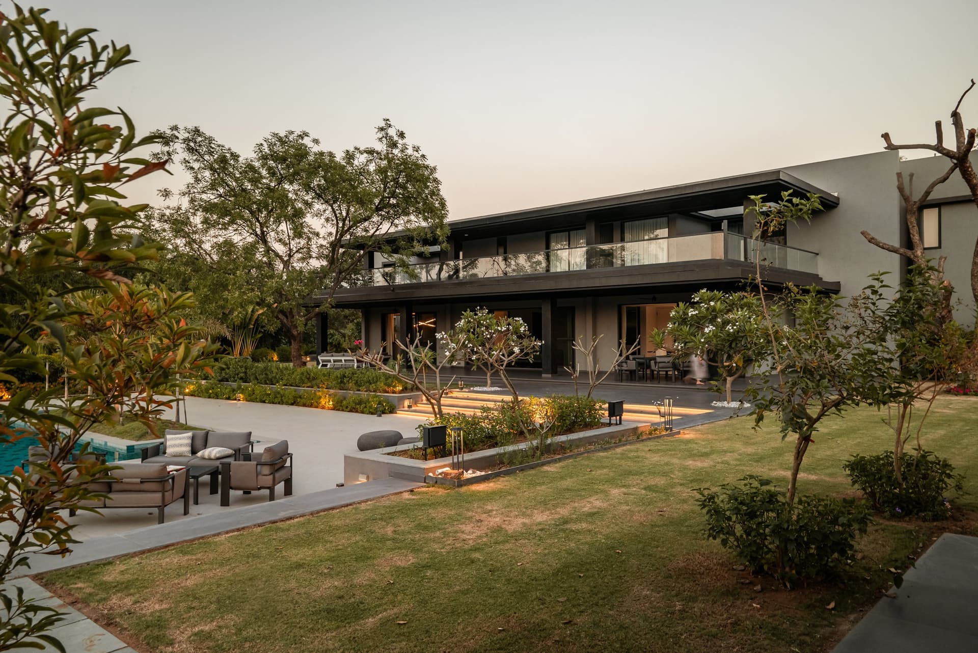 The rear elevation at dusk: a long horizontal volume sitting low on the land