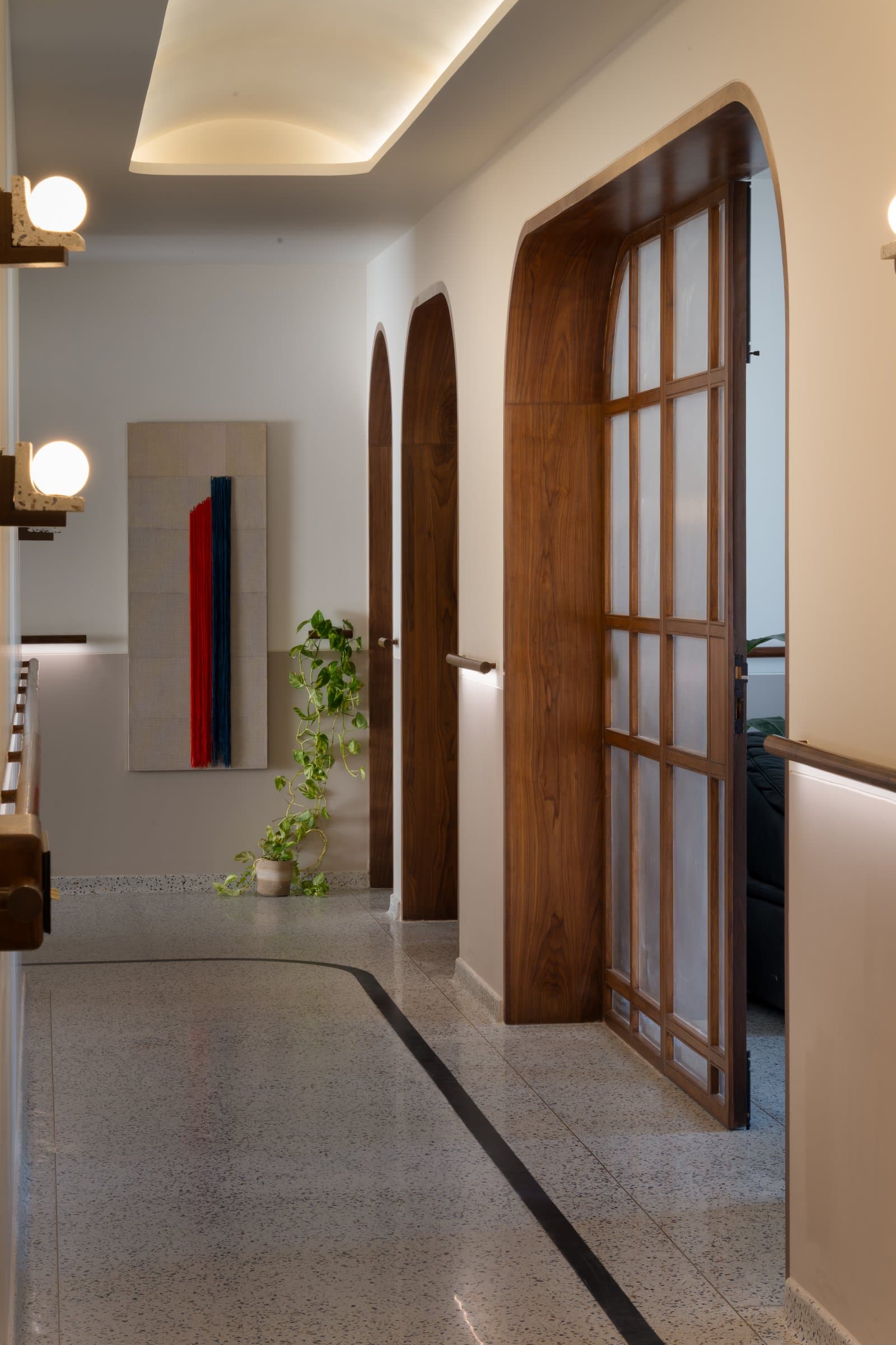 The bedroom corridor, treated as a room in its own right with twin arched doors and a textile artwork