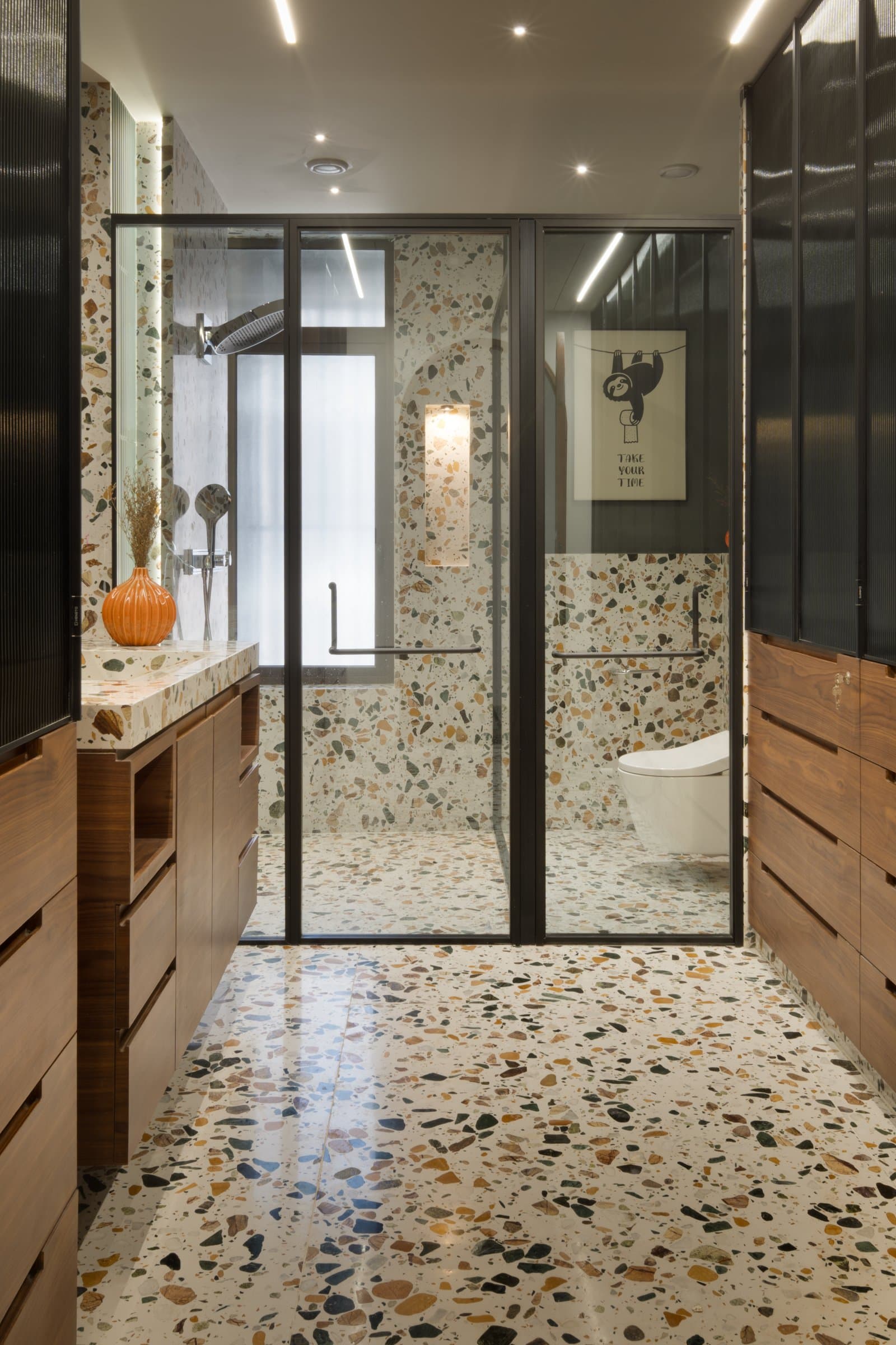 The bathroom, where multicoloured terrazzo covers floor and walls as a single continuous surface