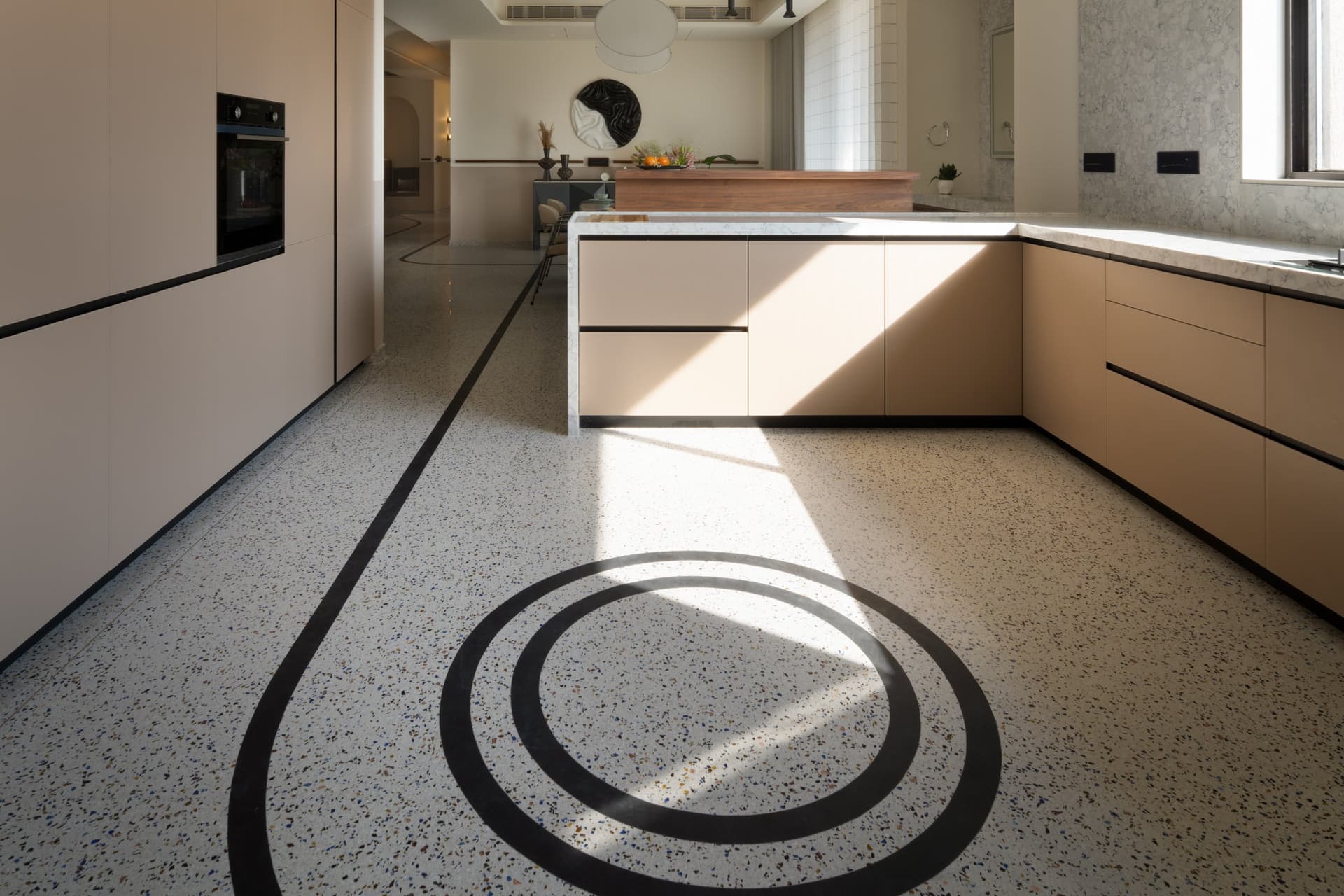 The kitchen, where concentric black circles in terrazzo become the room's only ornament
