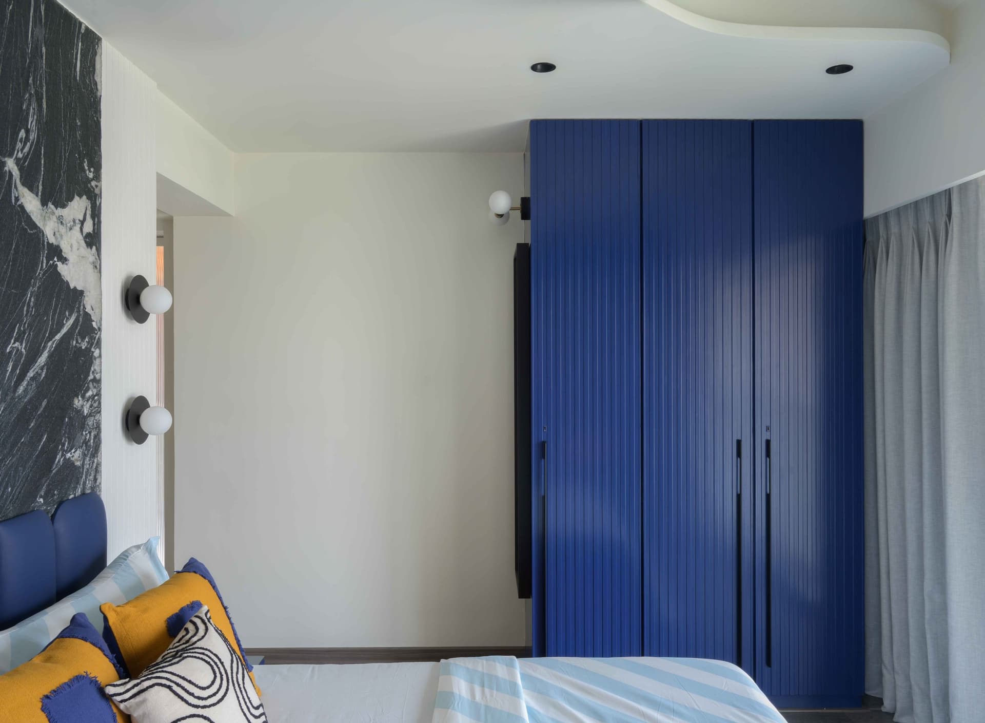 The royal blue fluted wardrobe wall opposite the bed