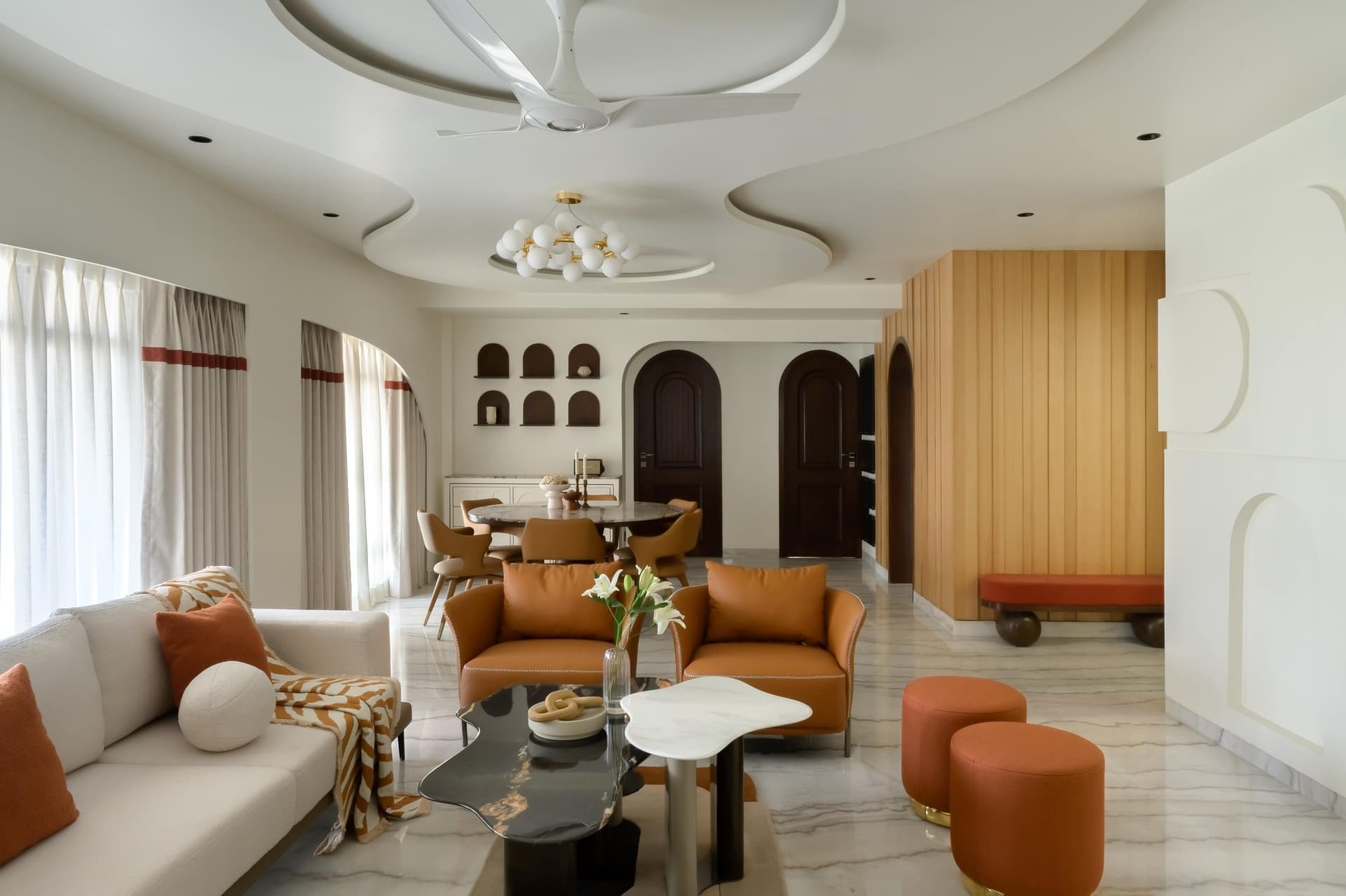 The living and dining volume, where a sculpted ceiling carries the geometry of the room from above