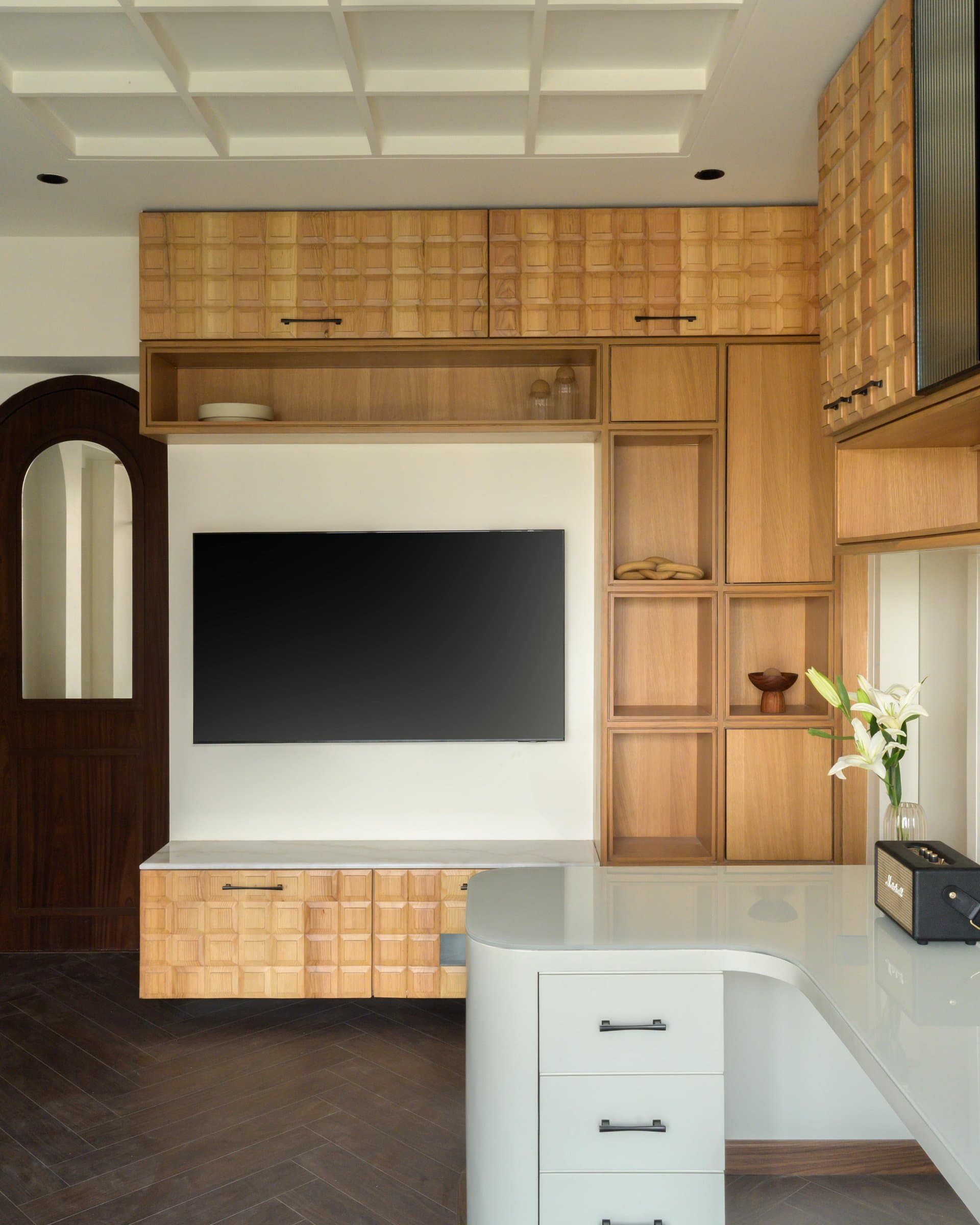 A wall of bespoke wood joinery, its uppers worked in a three-dimensional basket-weave