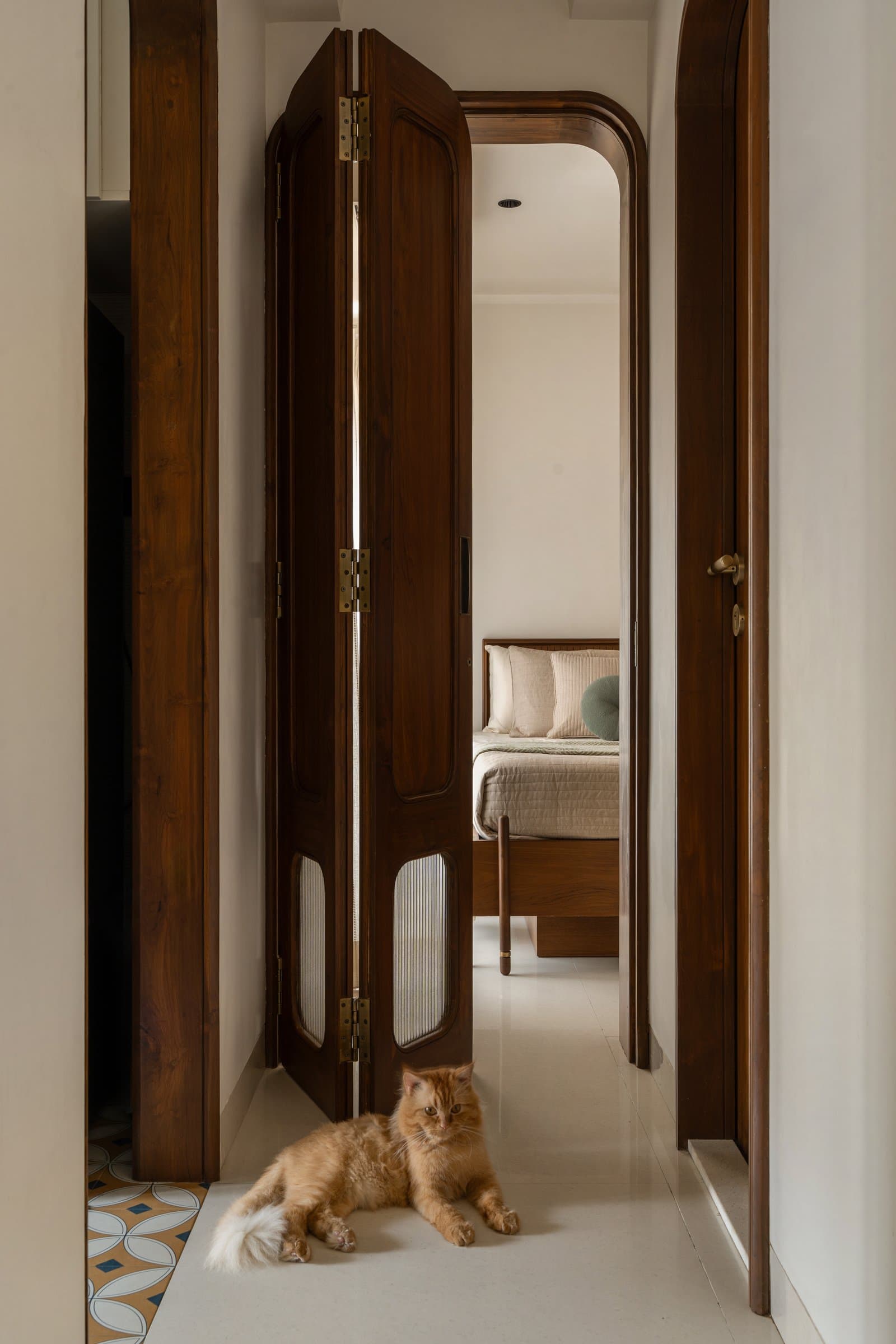 The bifold teak door with fluted glass inserts widens the perception of scale between living and bedroom