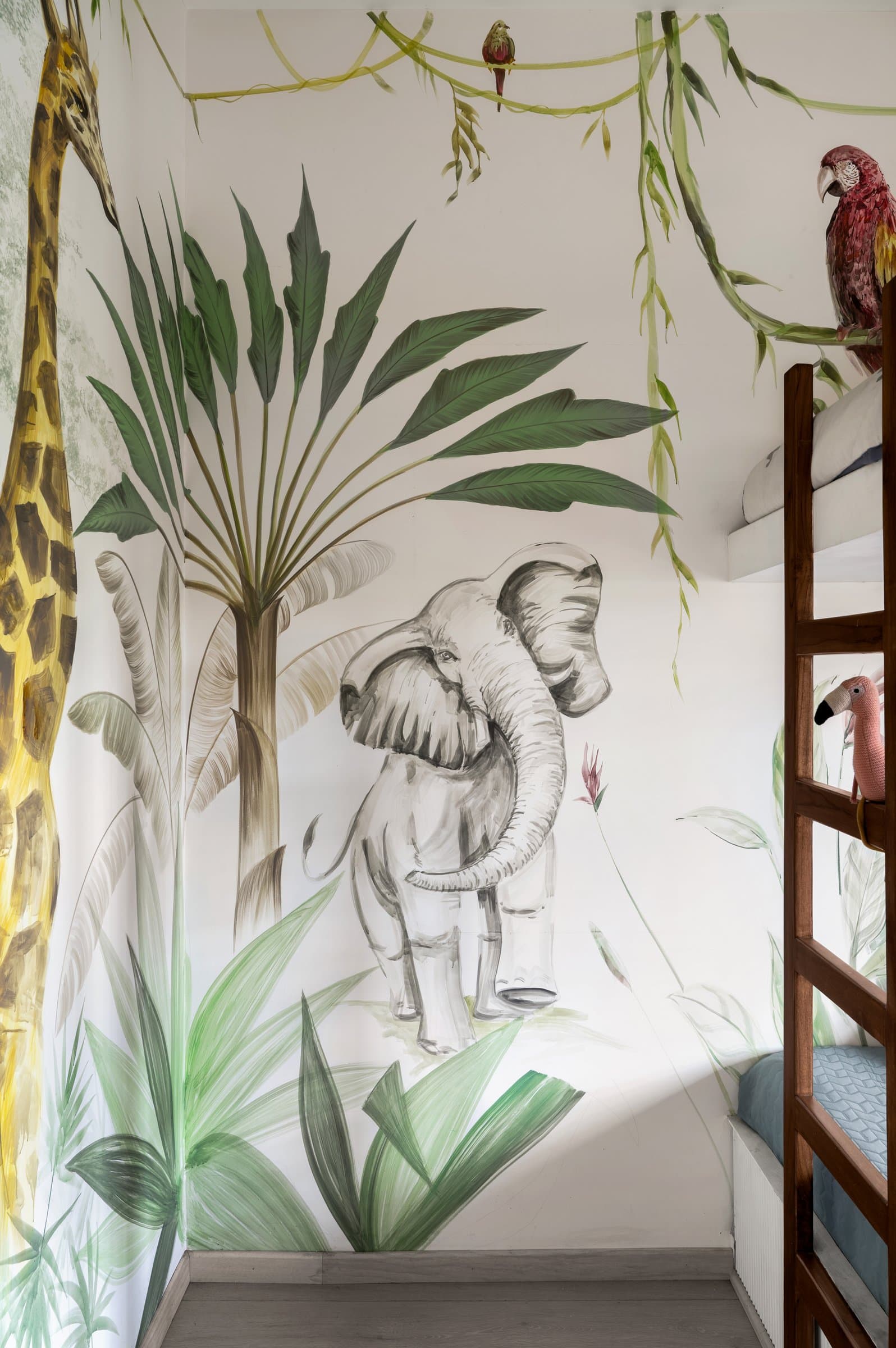 A second wall of the child's room, where a graphite elephant and a giraffe carry the mural's scale across the room