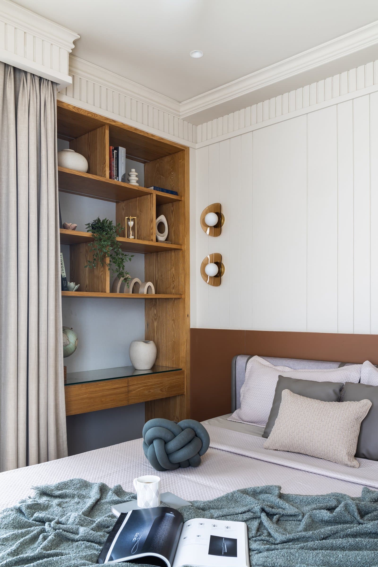 The same guest room, where built-in joinery folds a small writing surface into the shelving