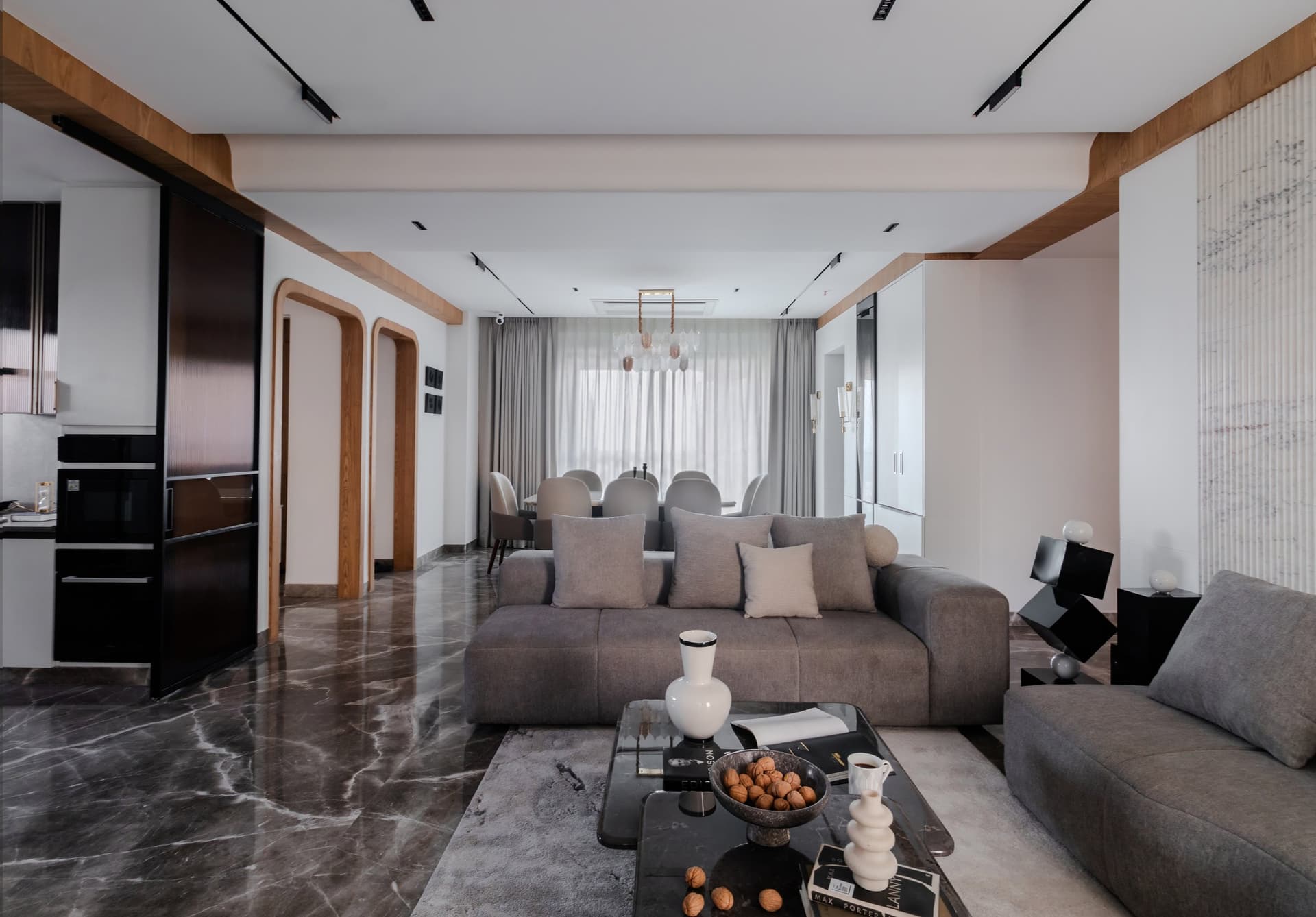 The living room opens into the home's principal volume, framed by a wooden beam that ties living to dining