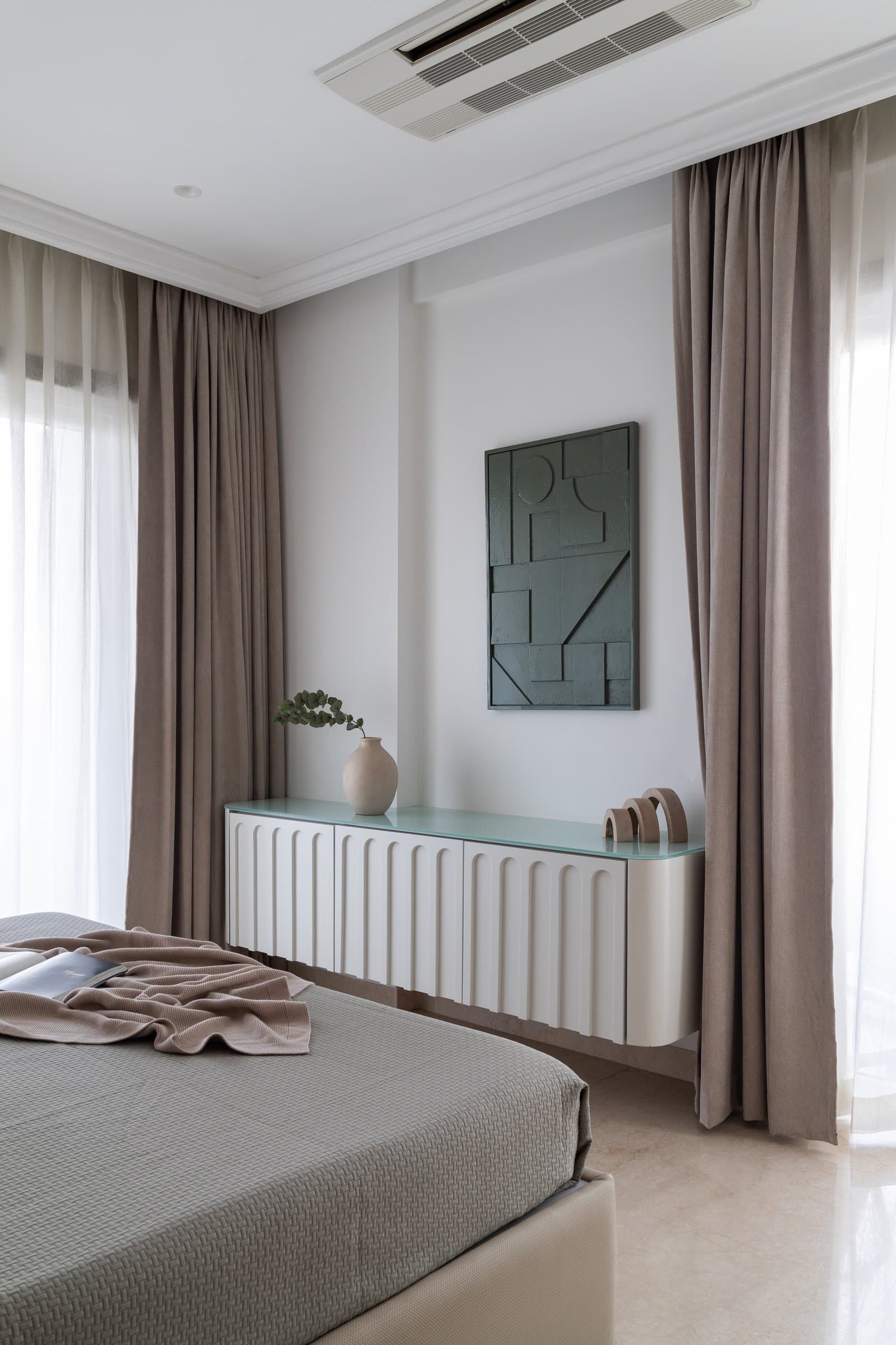On the opposite wall, a fluted cream console reinterprets a classical motif in a contemporary register