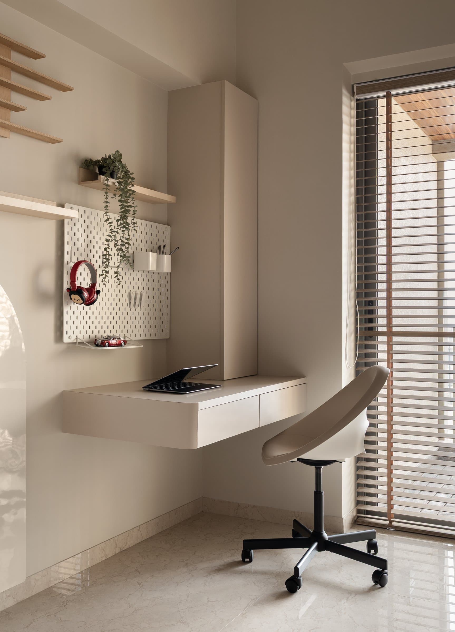 The study corner within the same room: a floating desk and slatted blinds offering economy and quiet for a child who will grow into it