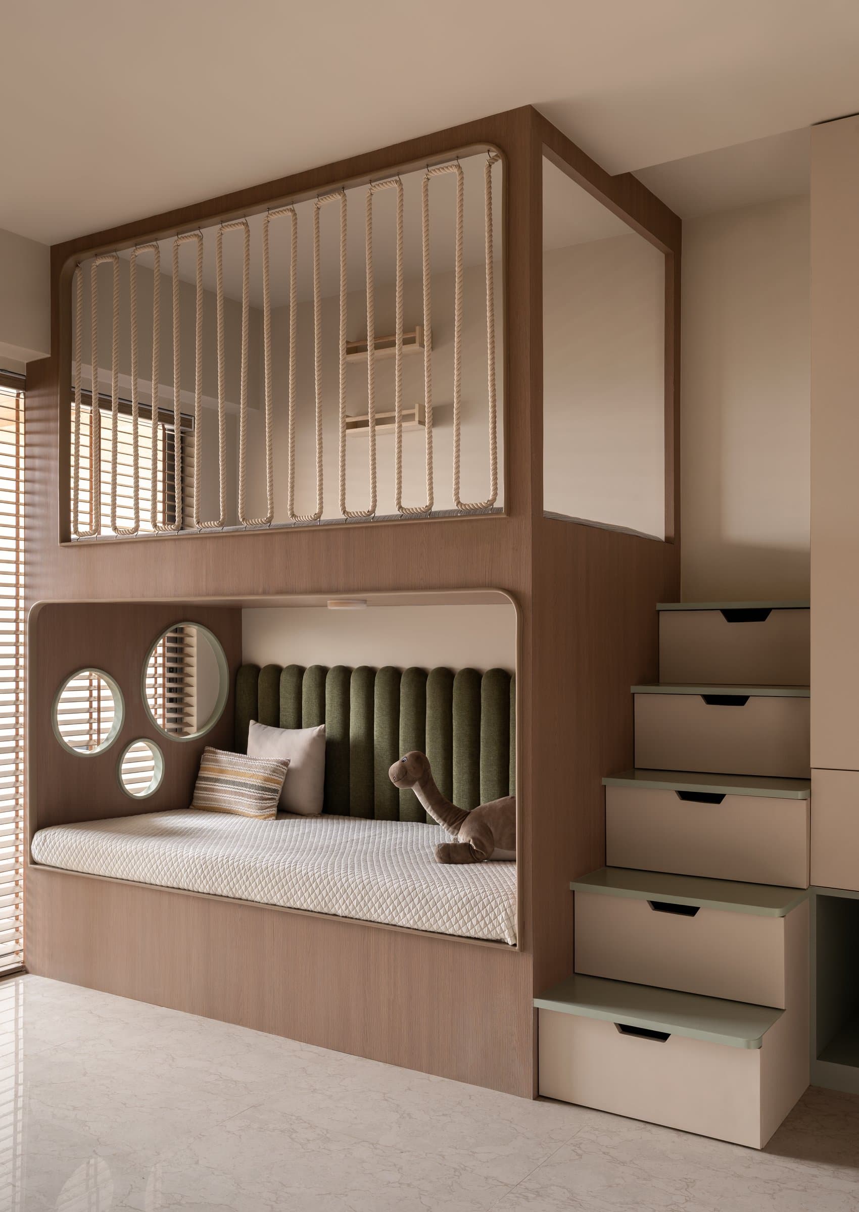 In the children's room, a custom bunk built into a warm wood volume folds sleep, storage, and play into a single architectural body