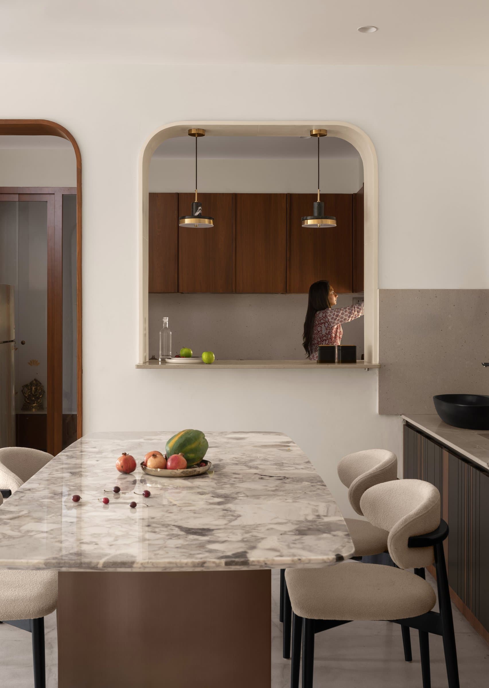 The arched opening between dining and kitchen, a curved threshold that softens the home's otherwise linear plan