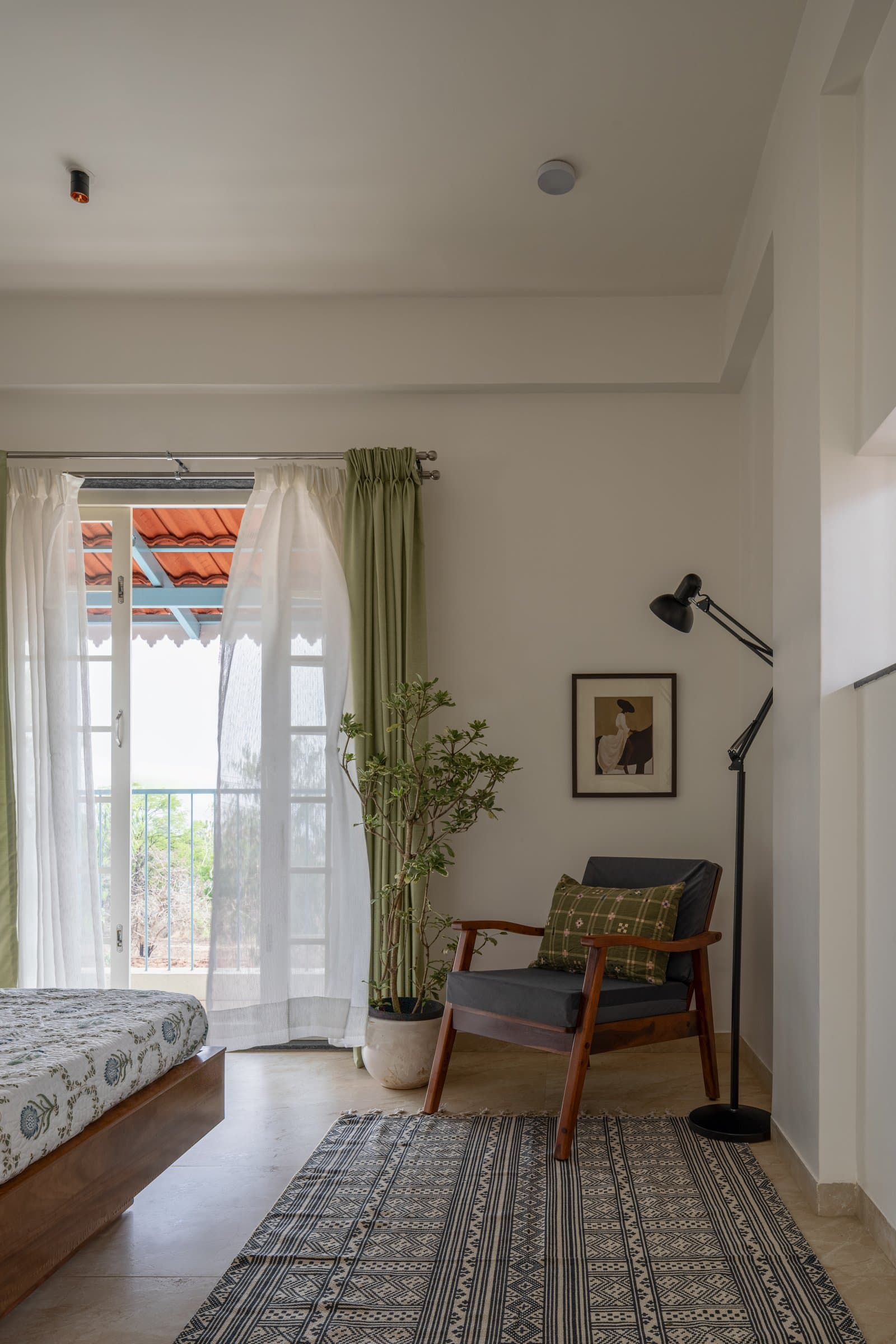 The second bedroom opens onto a balcony framed by the Mangalore-tile awning