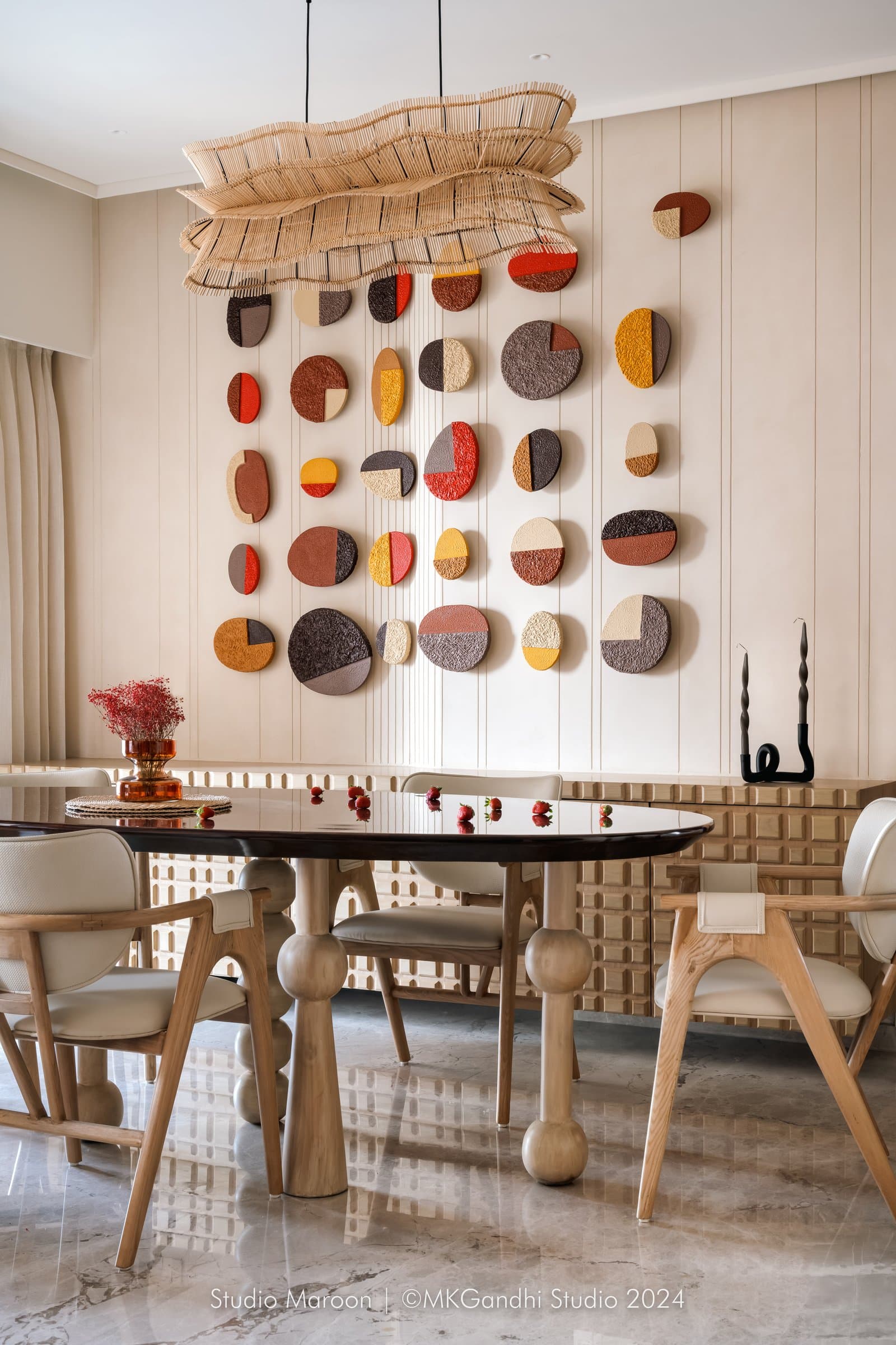 The dining wall: a composition of textured discs in the home's own mocha palette becomes the apartment's most expressive surface