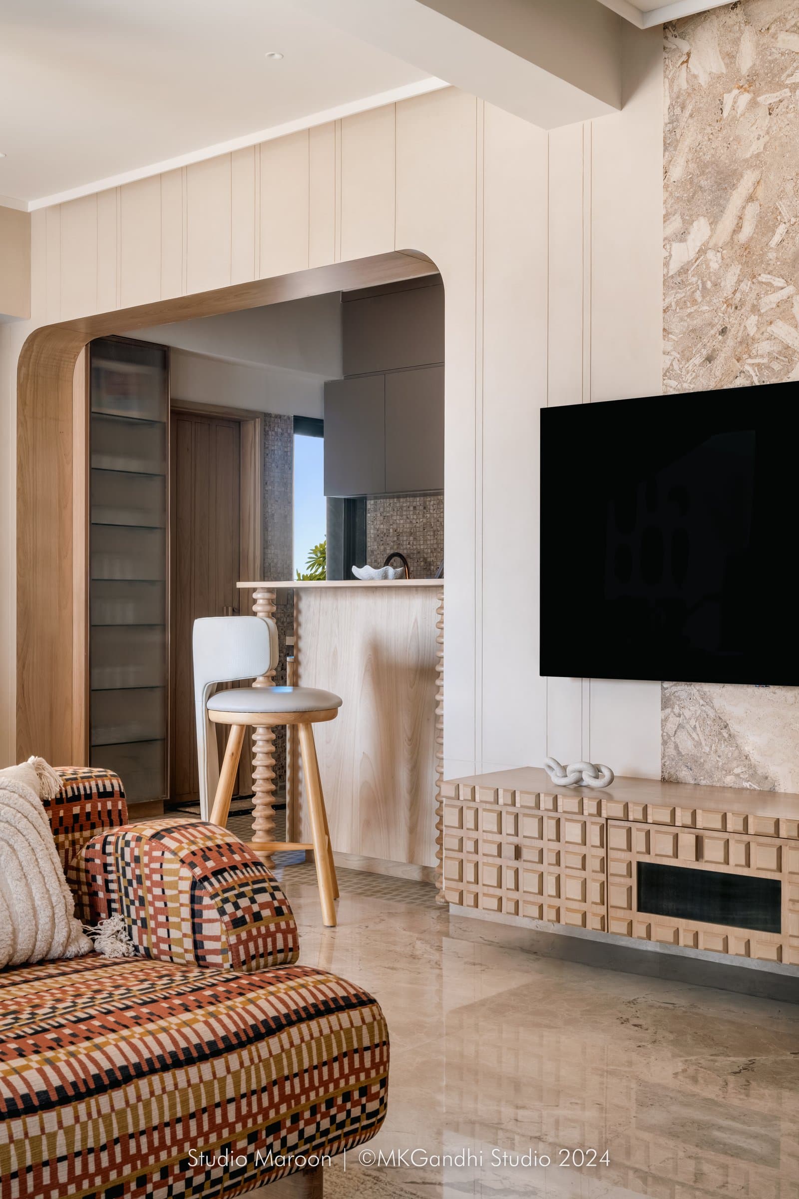 A second view of the living room, where the arched opening softens the transition toward the kitchen counter
