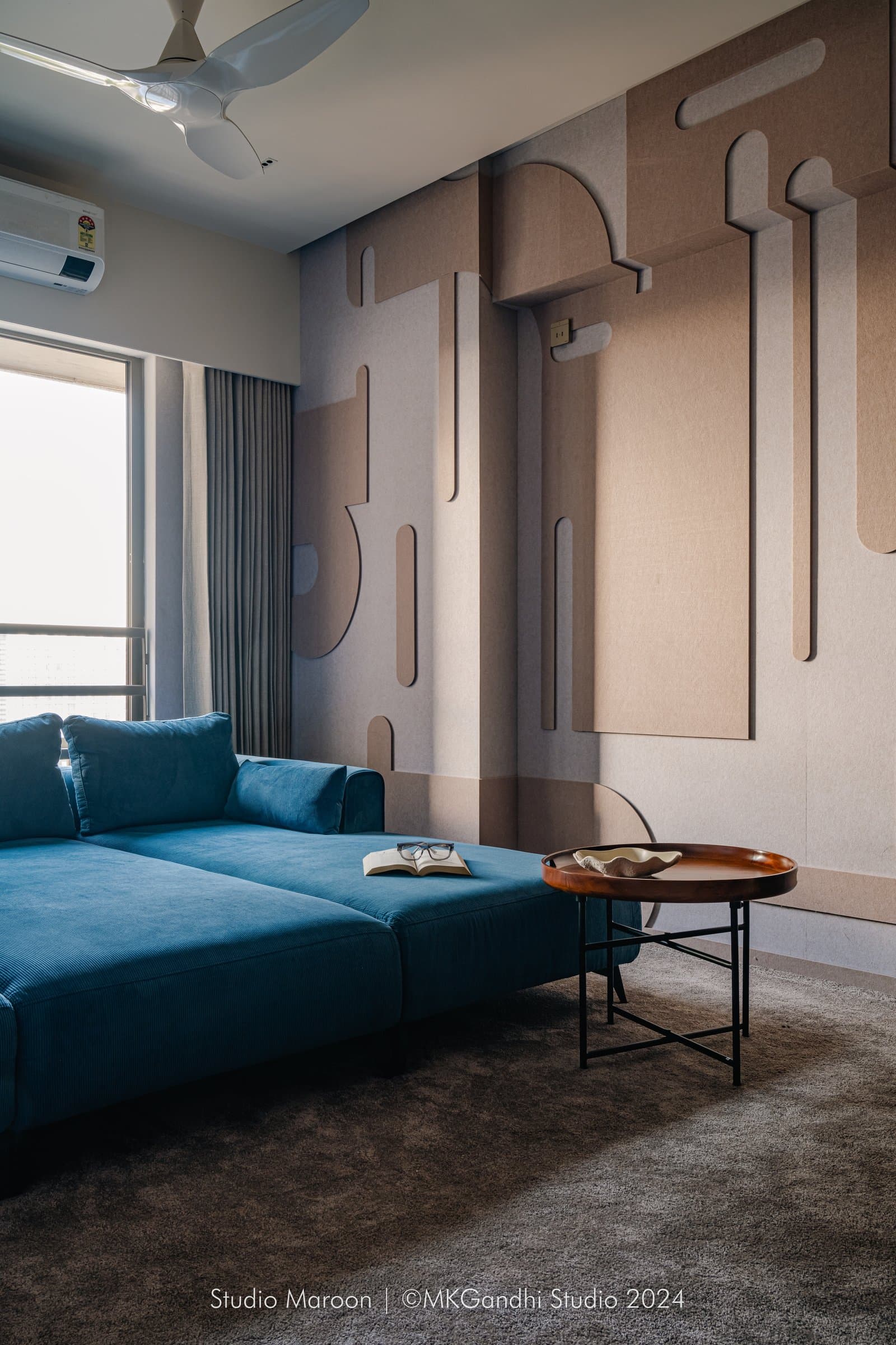 A reading corner in deep teal corduroy, the only sustained departure from the home's mocha palette