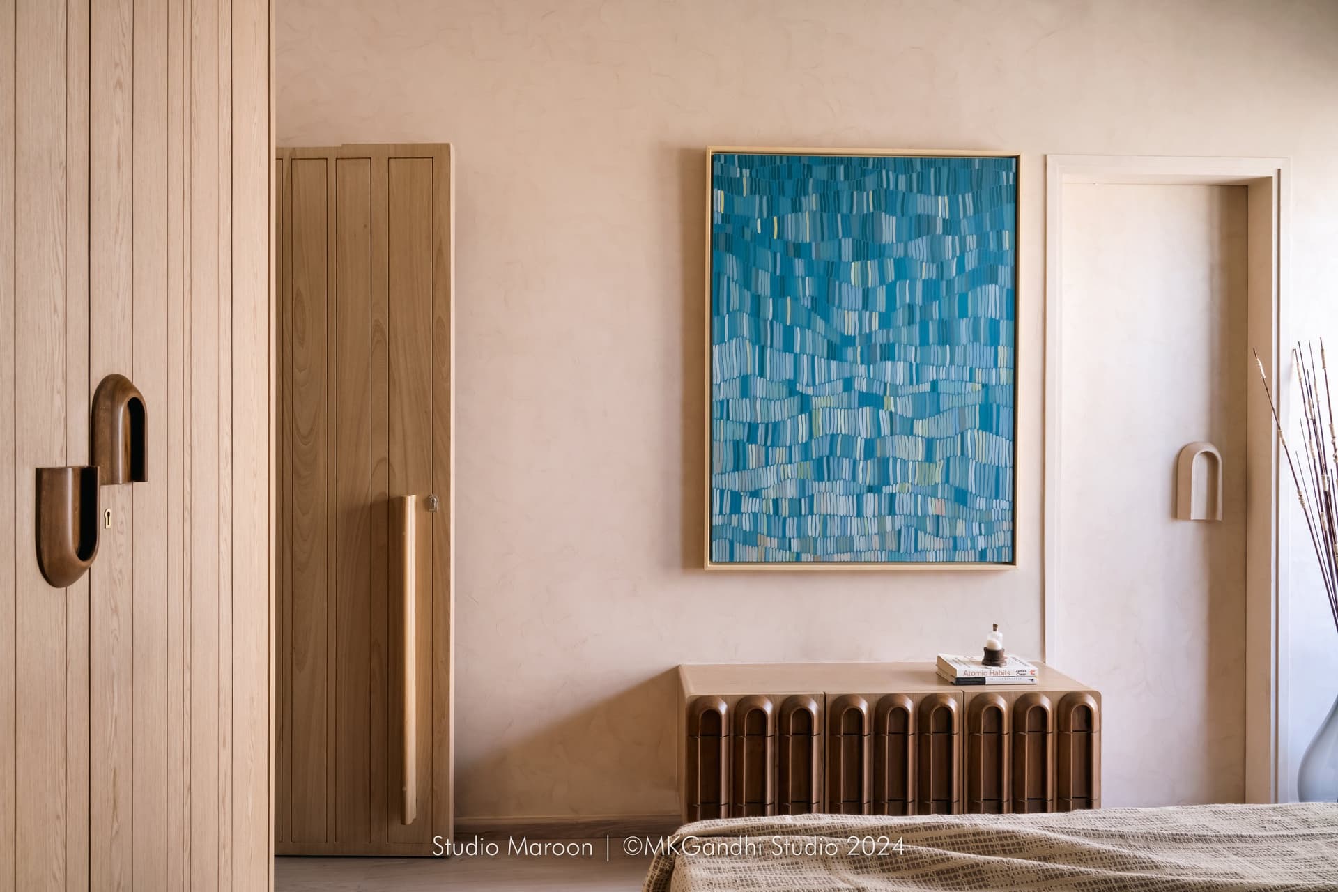 The opposite wall of the master bedroom, where an abstract blue painting echoes the home's reading-corner accent