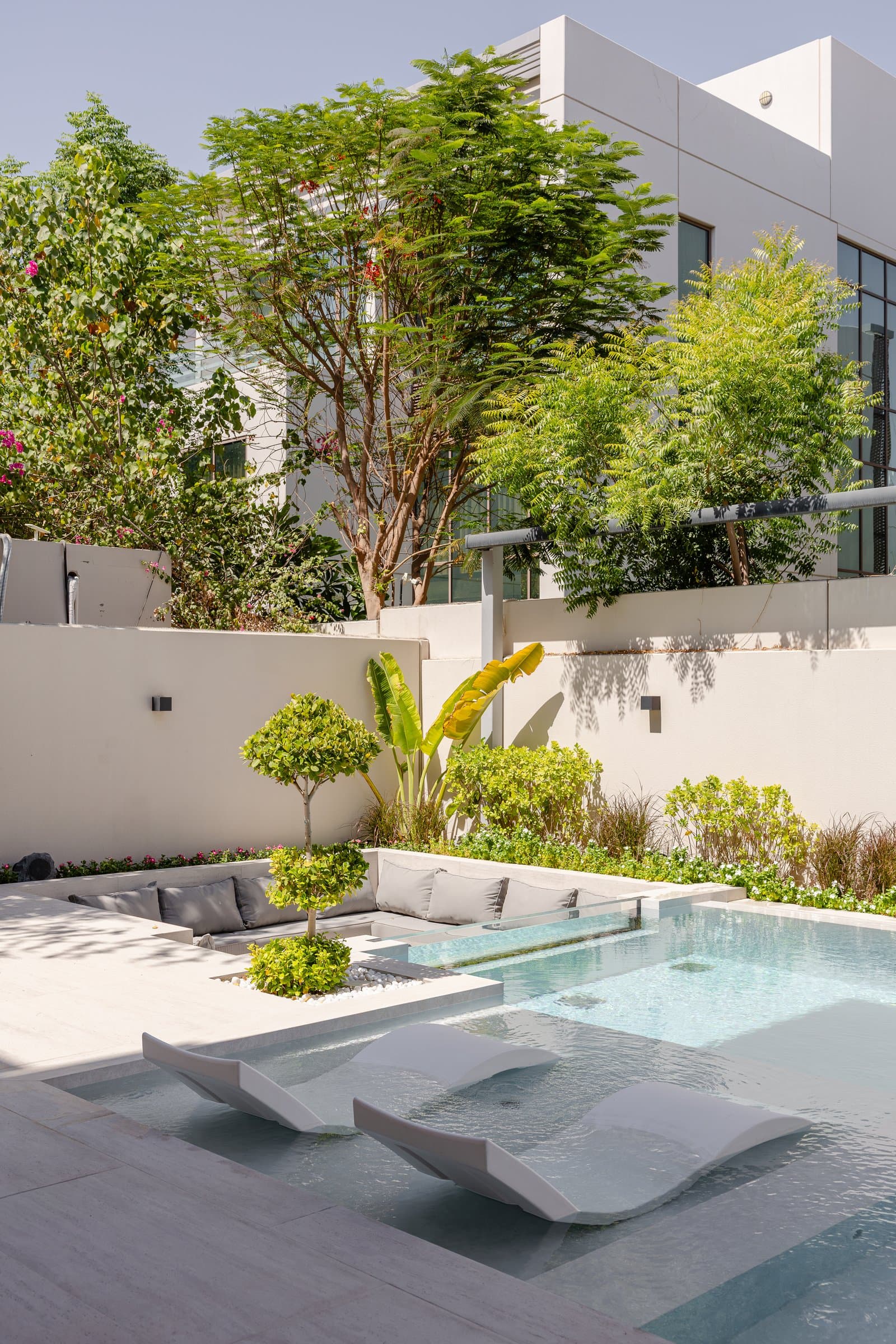 The sunken seating area, where built-in cushions and raised planters extend the architectural language outdoors