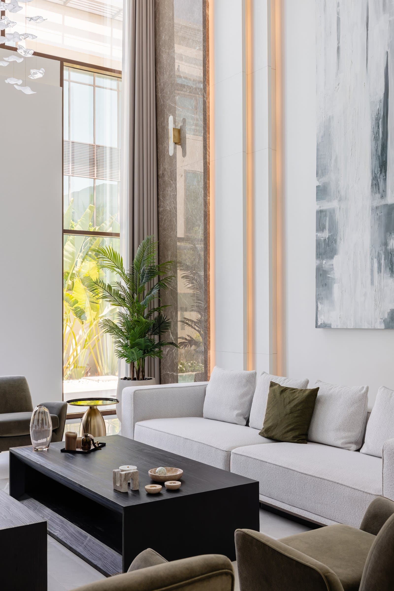 A closer view of the living room, where vertical cove lighting and a stone-clad spine articulate the room's full height