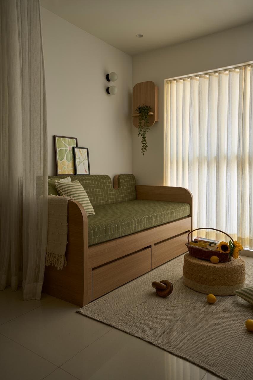 The daybed corner, where a checked olive upholstery and integrated drawer base transform seating into sleeping into storage