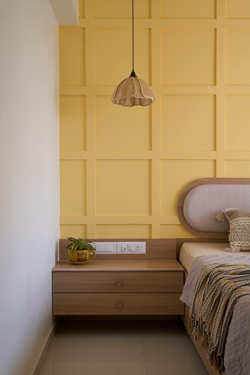 The bedside detail, where the panelled wall's grid meets floating oak drawers in a study of quiet proportion