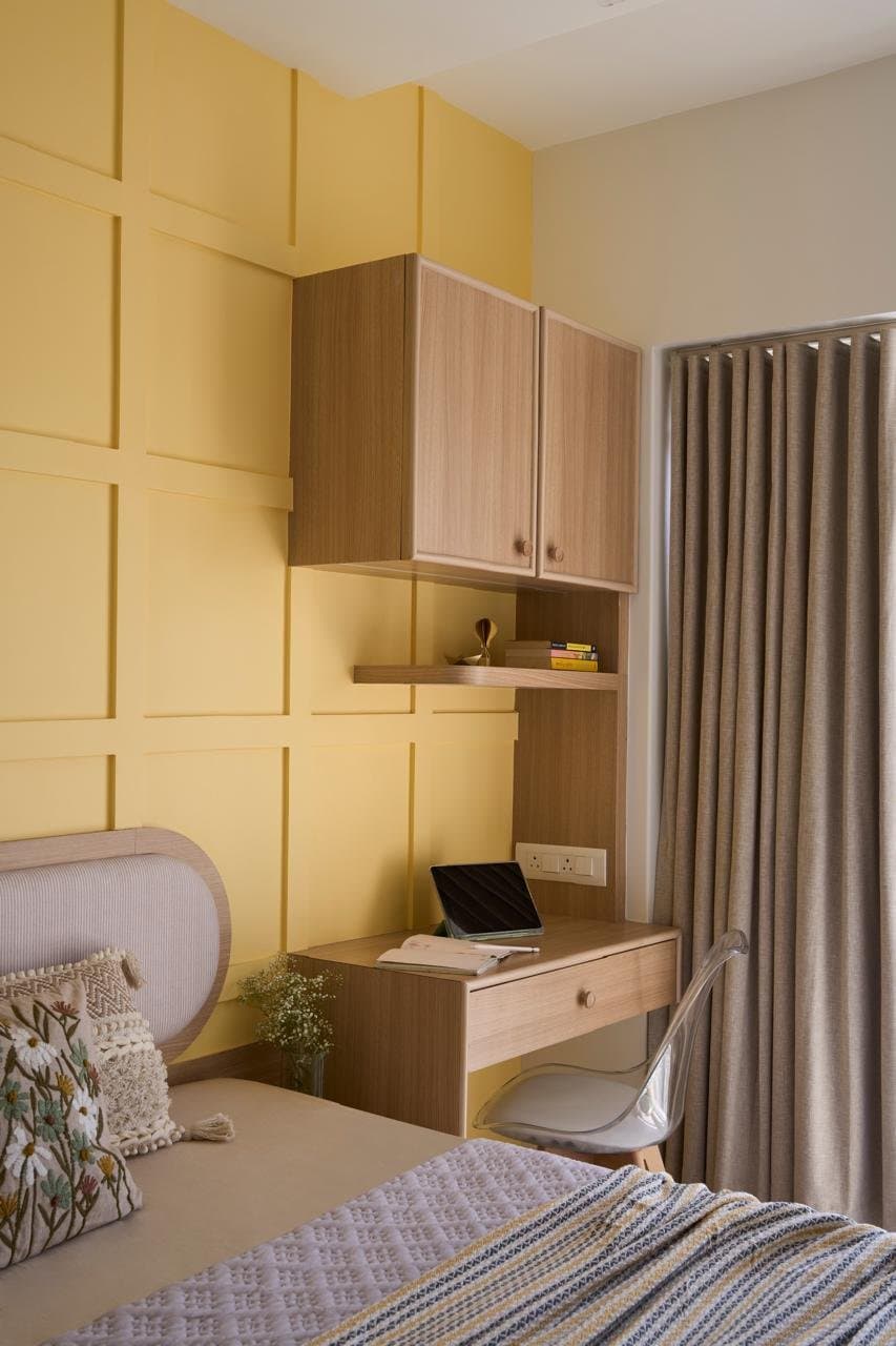 The study nook, where a wall-mounted desk and floating cabinet tuck into the yellow panelling without disturbing its rhythm