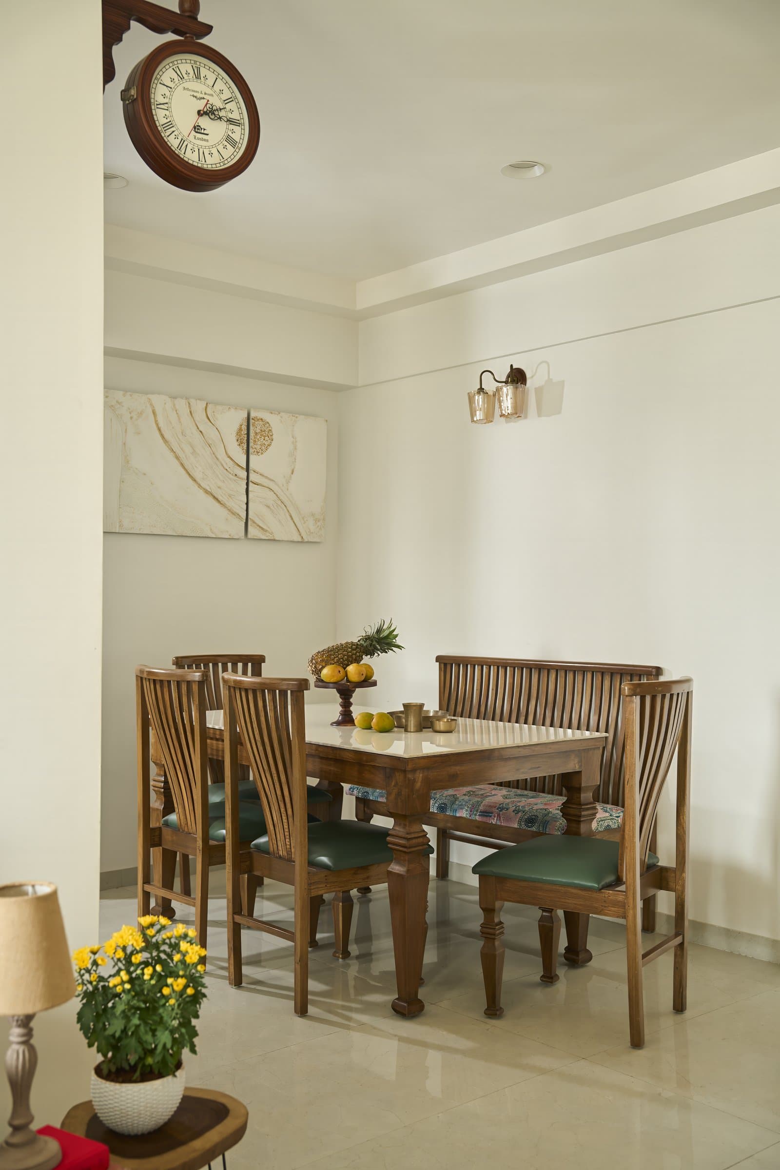 The dining area, anchored by a compact table with slatted wooden chairs and a corner bench in deep green upholstery
