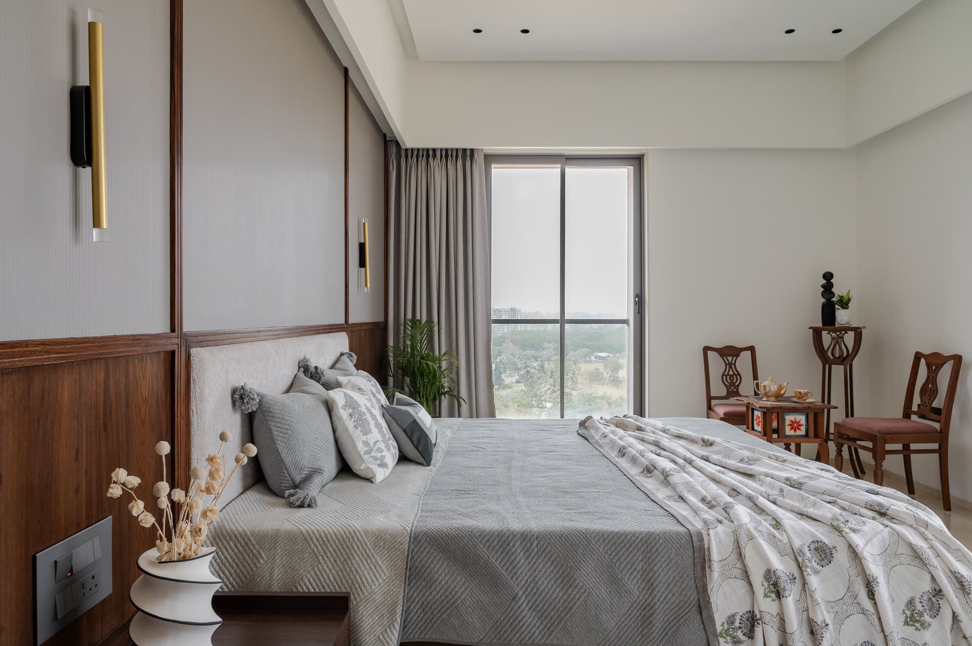 The master bedroom, extending toward full-height glazing and a view of trees beyond