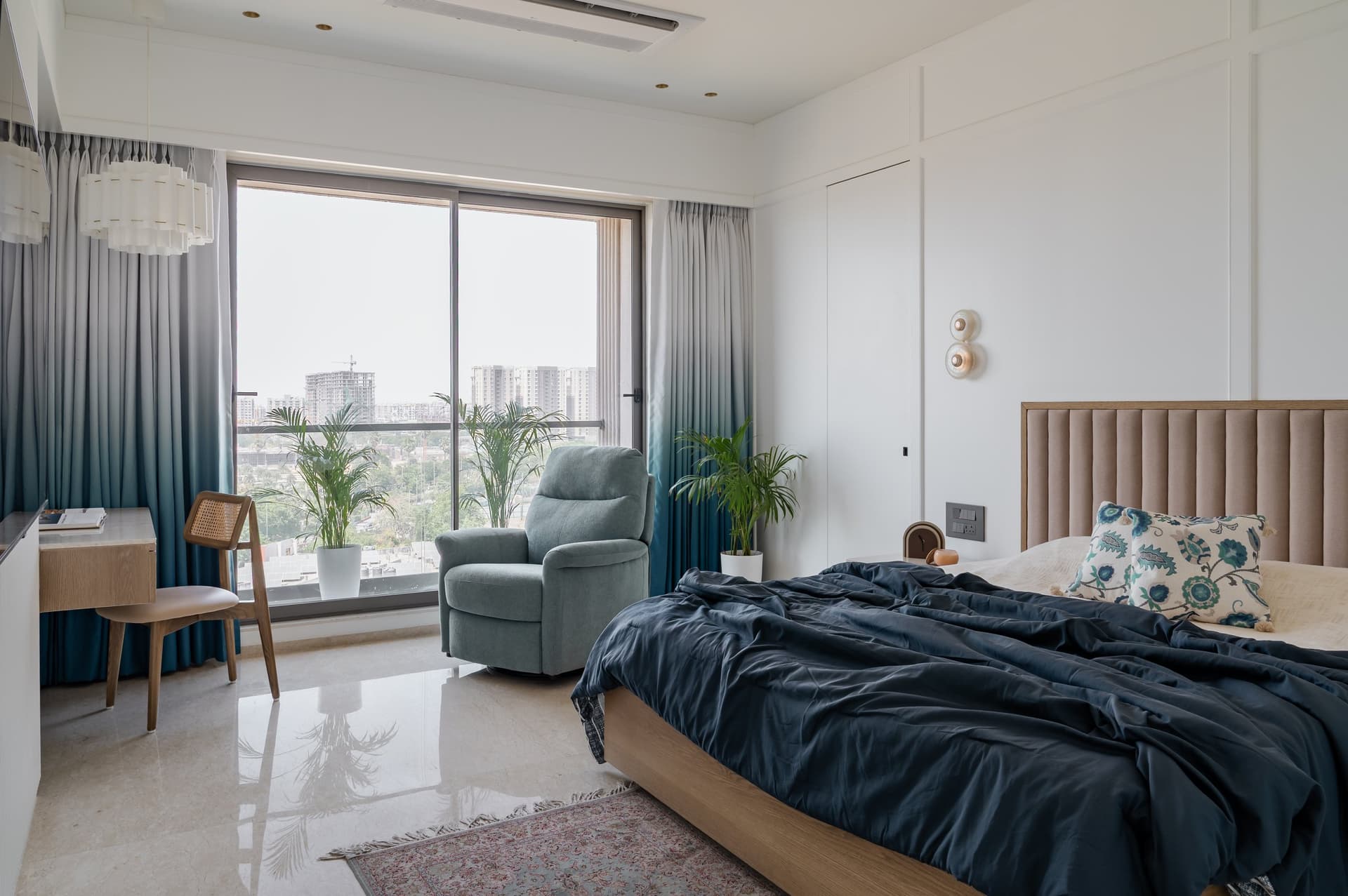 The second bedroom, where ombré curtains graduate from pale silver to deep teal at the floor