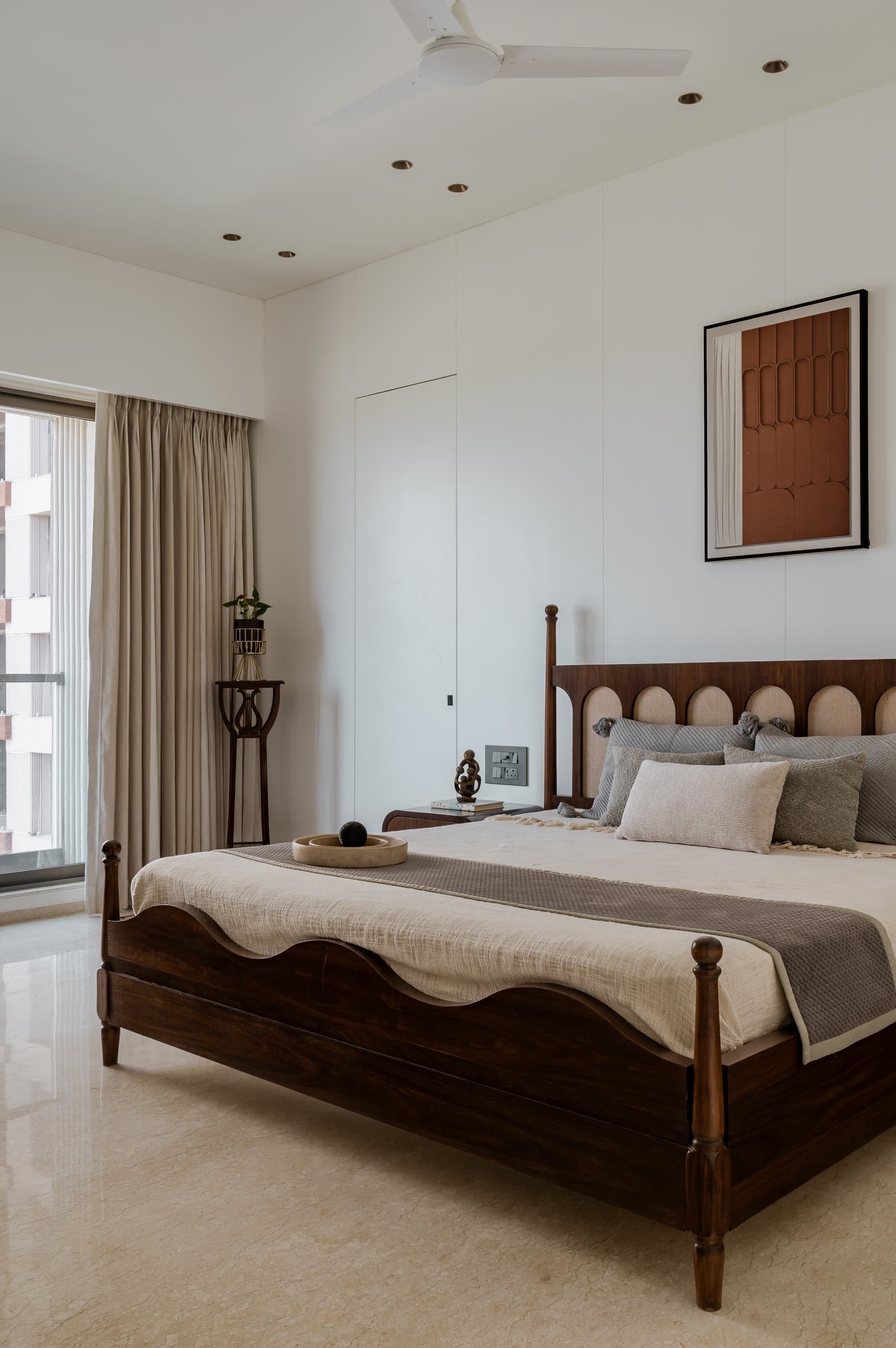 The third bedroom, a carved four-poster in dark rosewood set against a panelled white wall