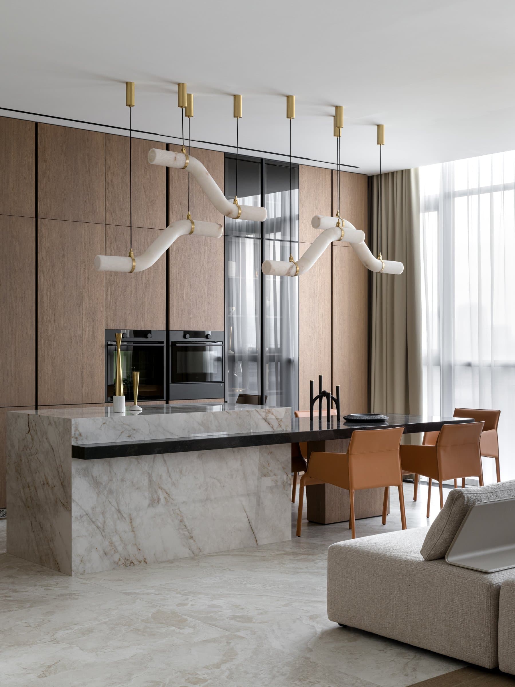 The island seen from the living side, its solid porcelain mass crowned by a darker stone dining surface